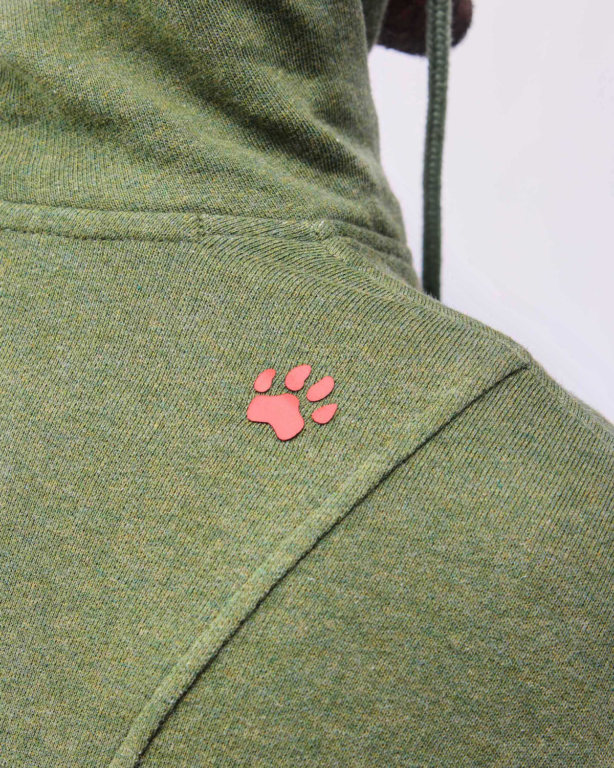 Close-up of an orange paw print on an olive green Urban Sweatshirt.