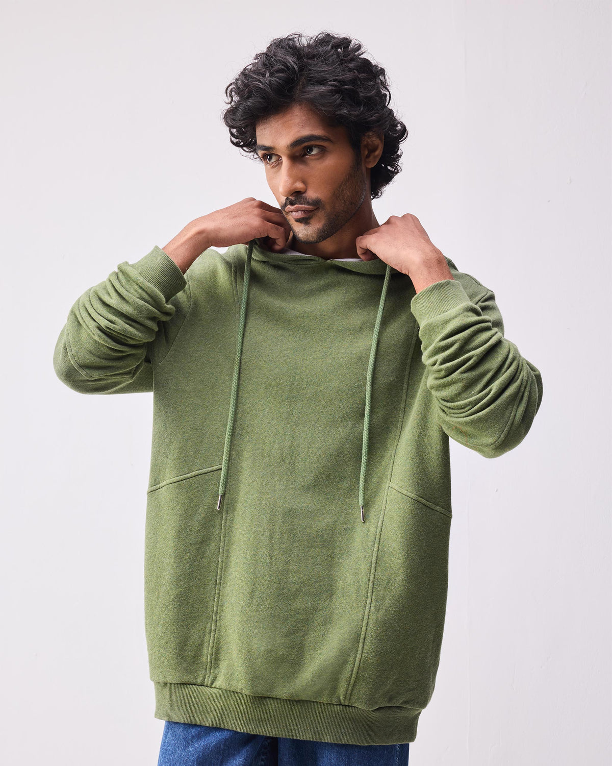 Person wearing an oversized olive green Urban Sweatshirt hoodie.
