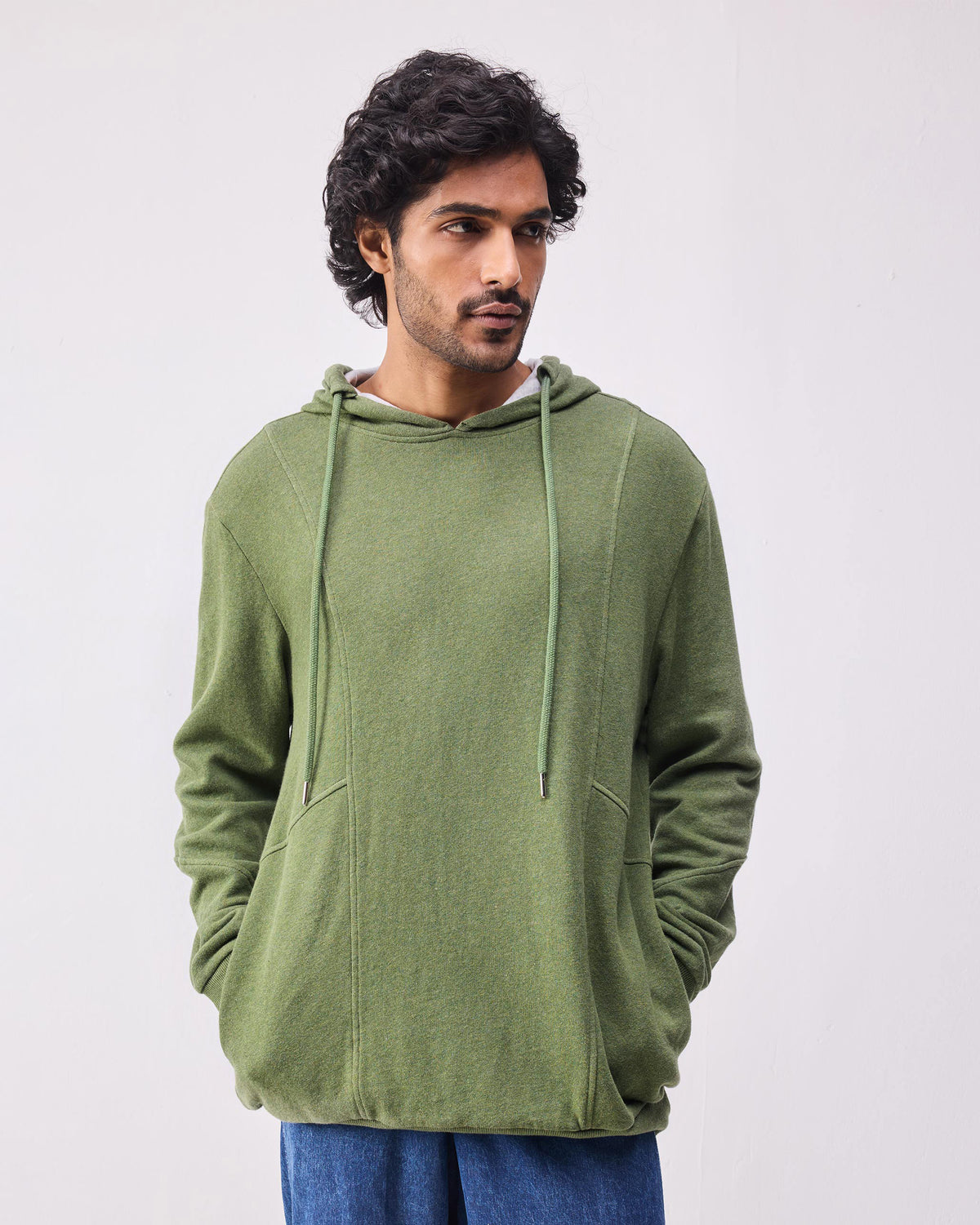 Olive green Urban Sweatshirt hoodie with hands in the side pockets.