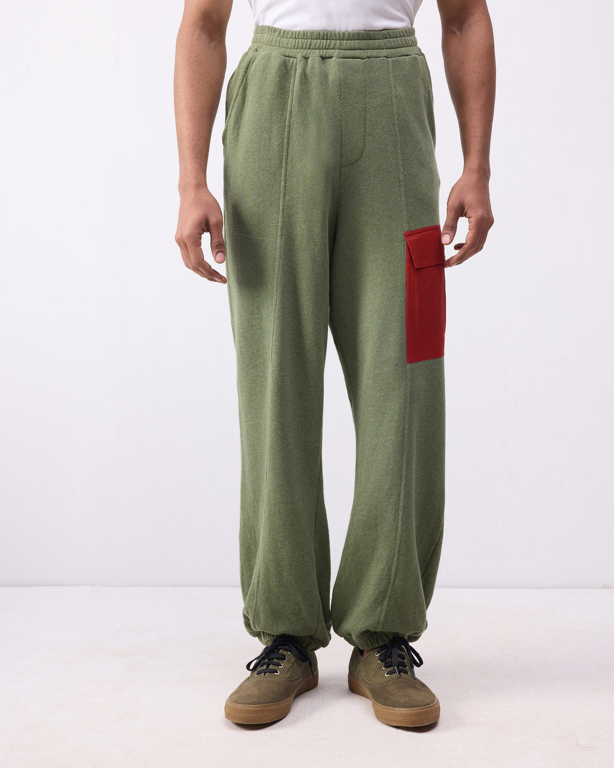 Person wearing green Lounge Pants with a red thigh pocket and elastic ankle cuffs.