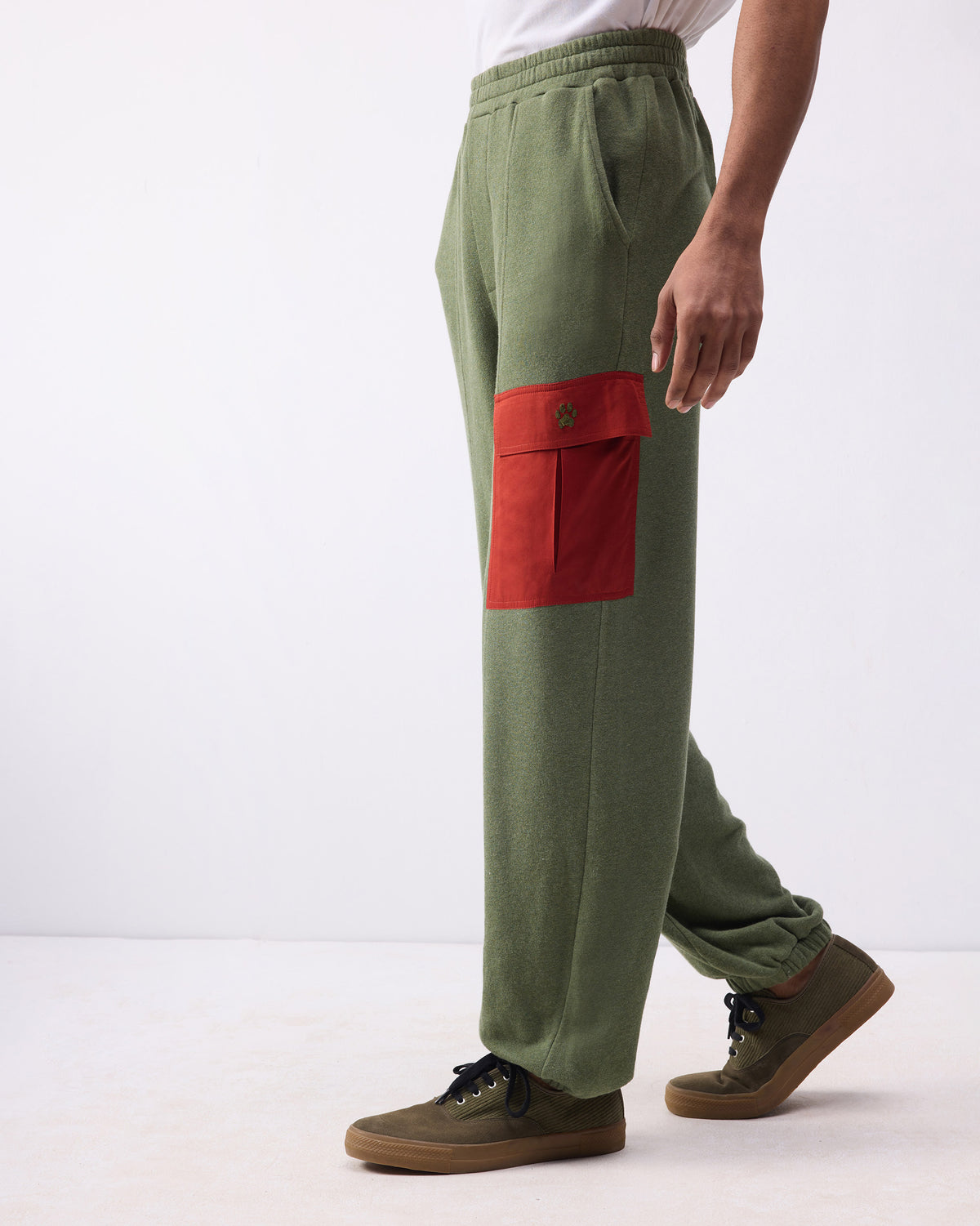 Side view of green Lounge Pants with a red cargo pocket on the thigh.