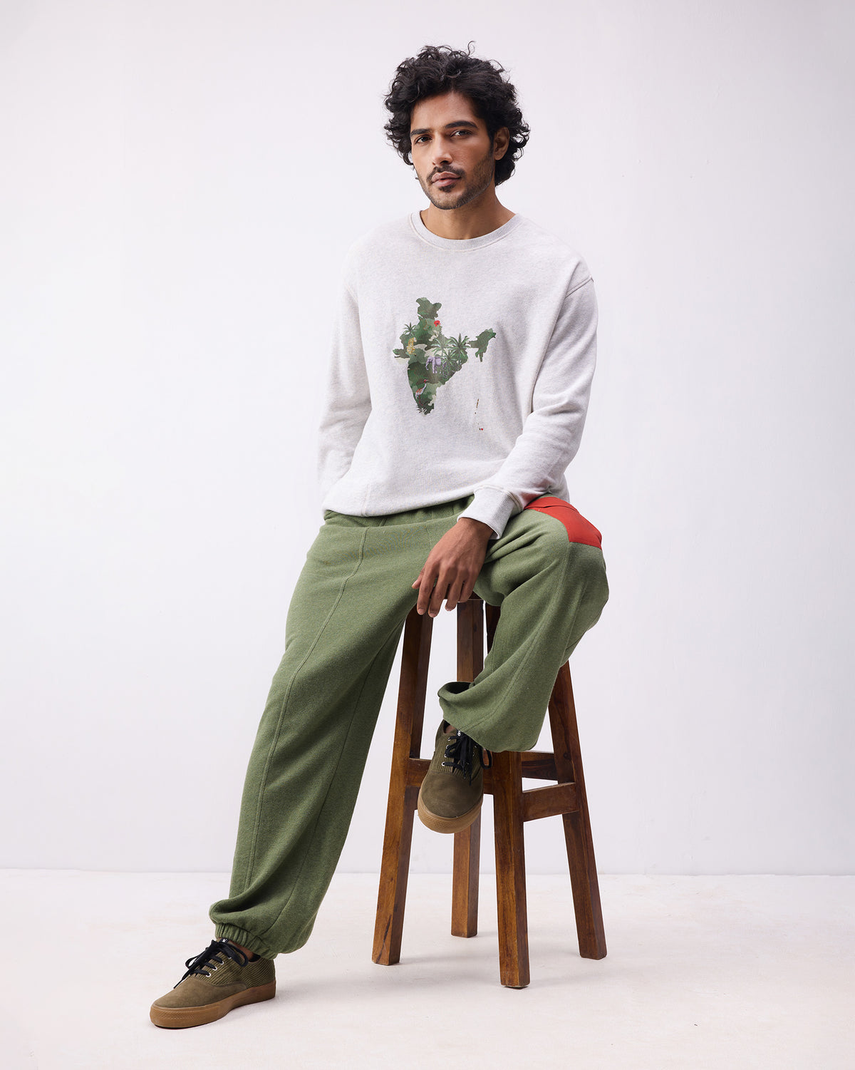 Person wearing green Lounge Pants with elastic cuffs and a red thigh pocket.