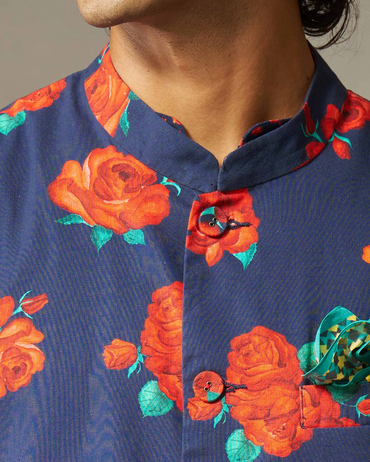 Close-up of a navy Nehru jacket with red roses and a patterned pocket square.