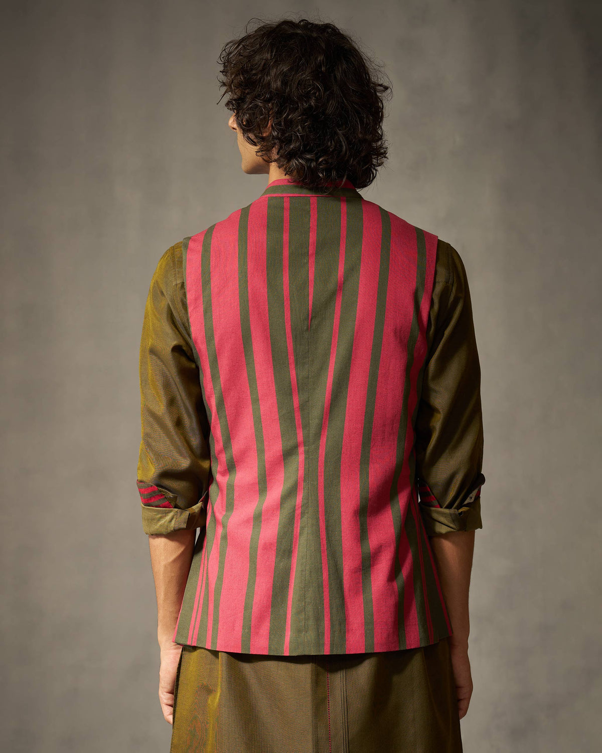 Back of a red and oak brown striped Nehru jacket worn by a person.