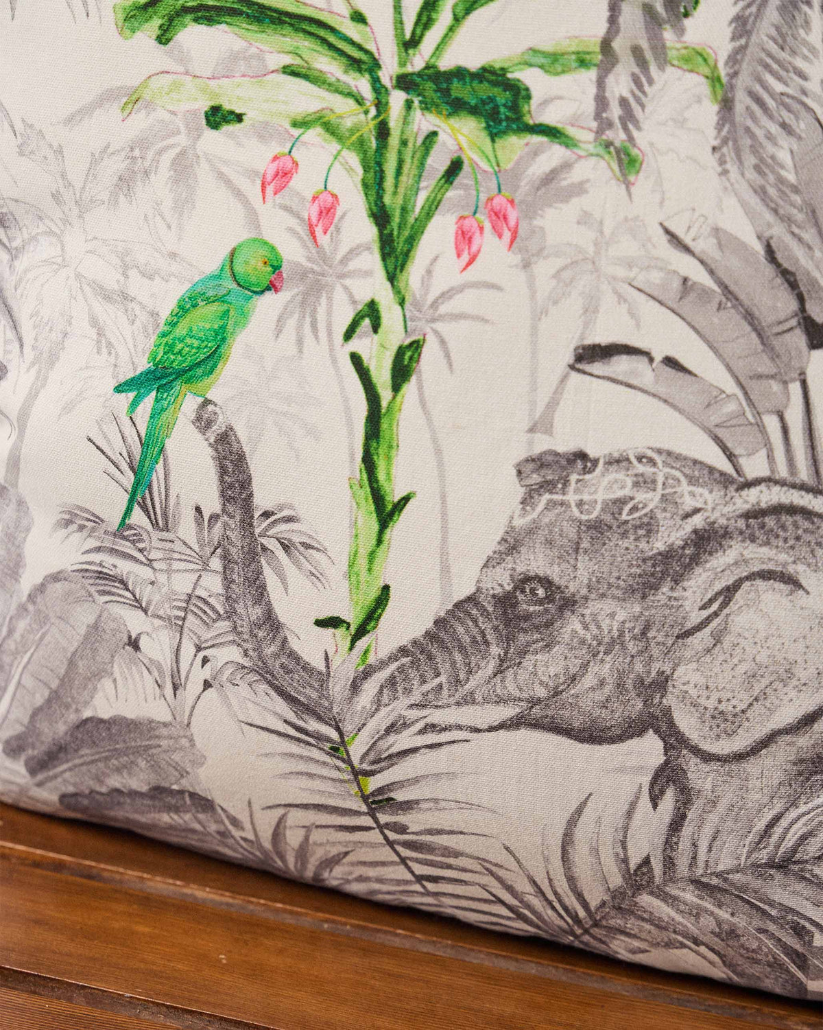 Close-up of Ceylon Ele cushion print with elephant trunk and green parrot.