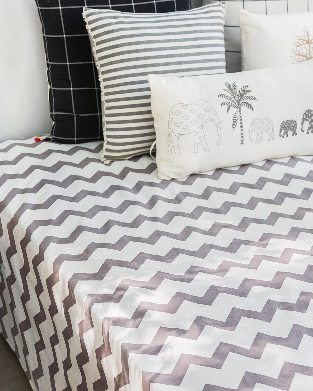 Grey and white Colombo Wave bedsheet with a chevron pattern on a bed.