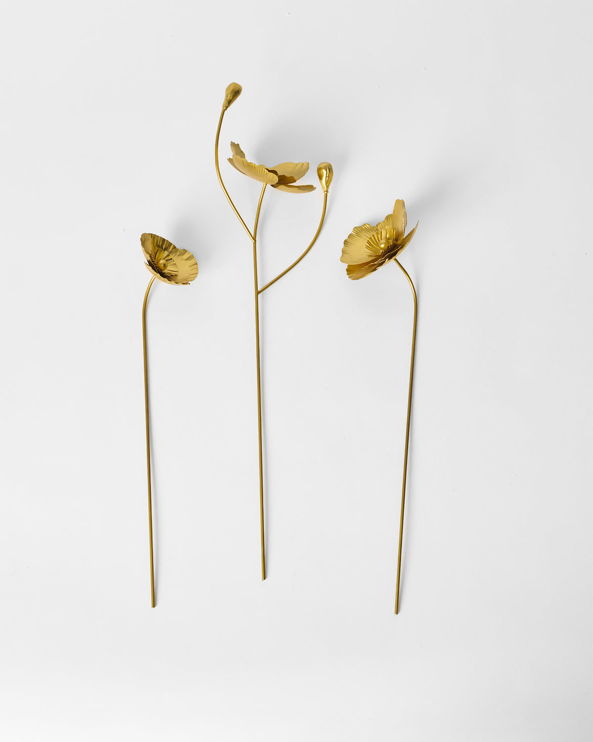 Three gold metal Poppy accent stems standing upright as a set of three.