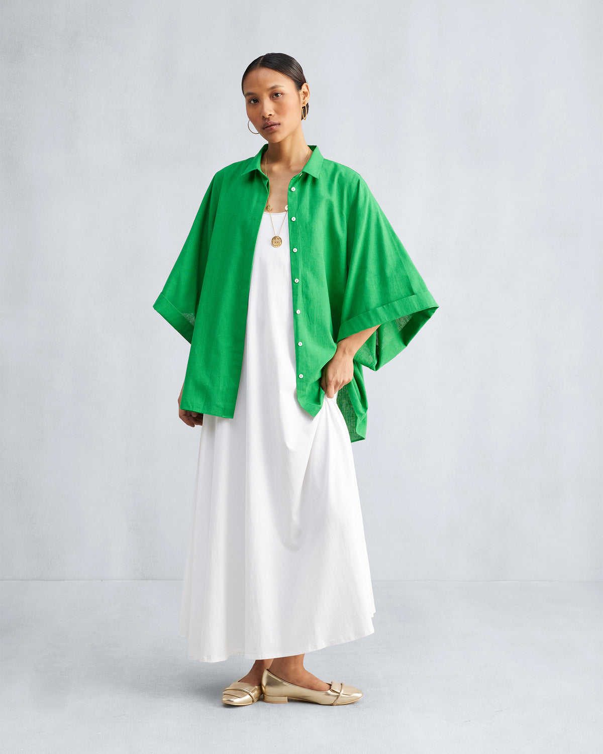 White Esther dress styled under an open green shirt.