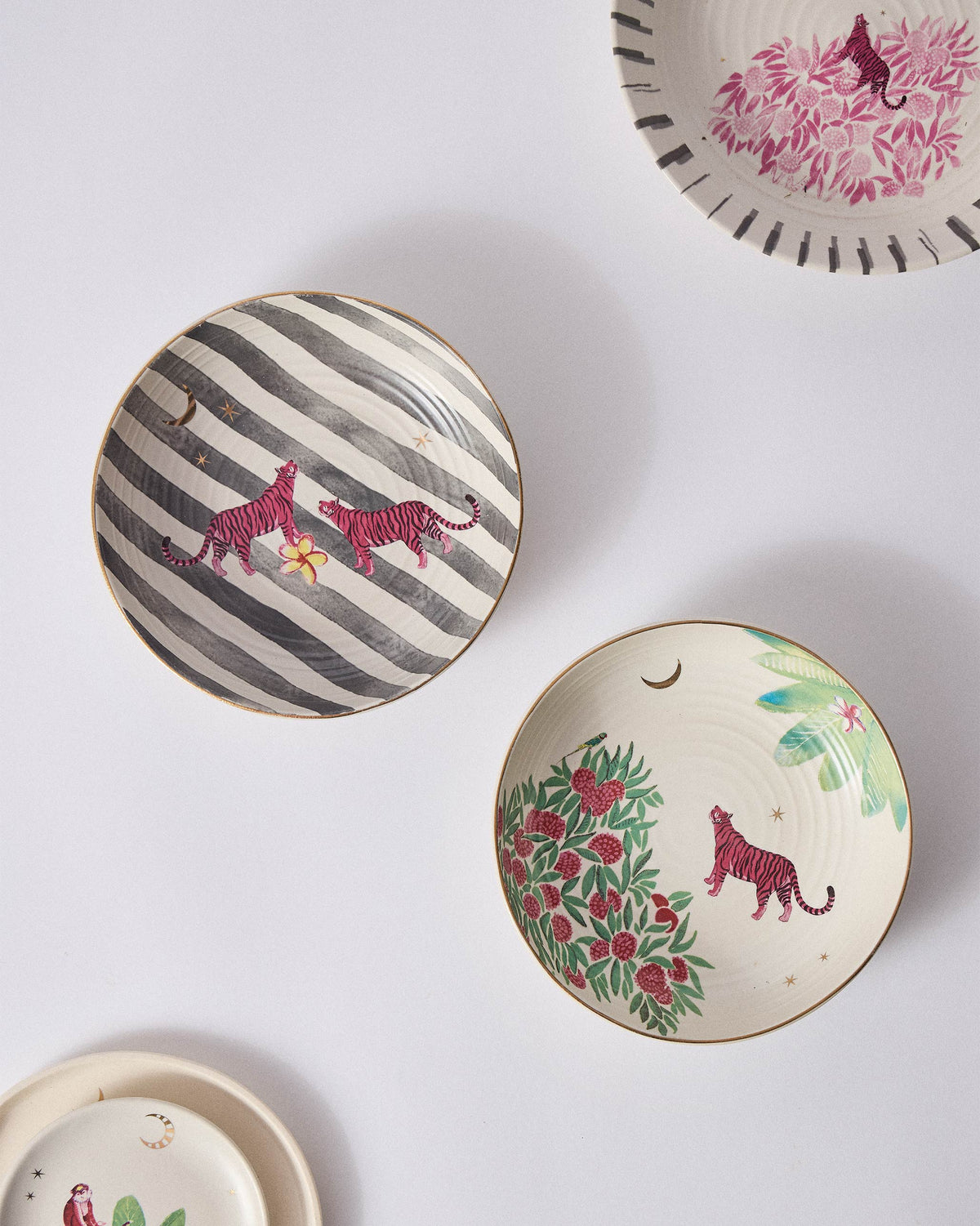 Ceylon Trail Shallow Bowls with pink tigers on striped and leafy interiors.