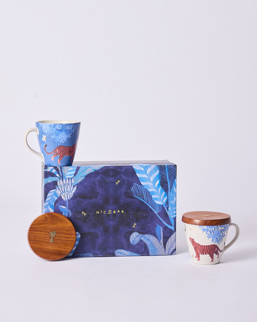 The Nadi mugs and a wooden lid in front of the navy tropical gift box