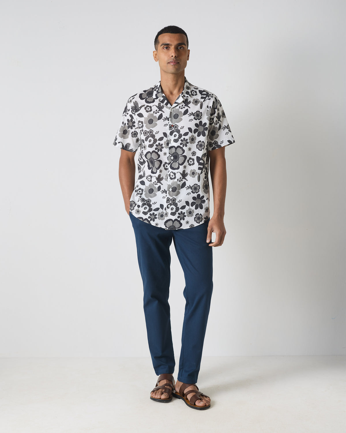 Person wearing a black and white Mistari shirt with a floral bird print to the hip.