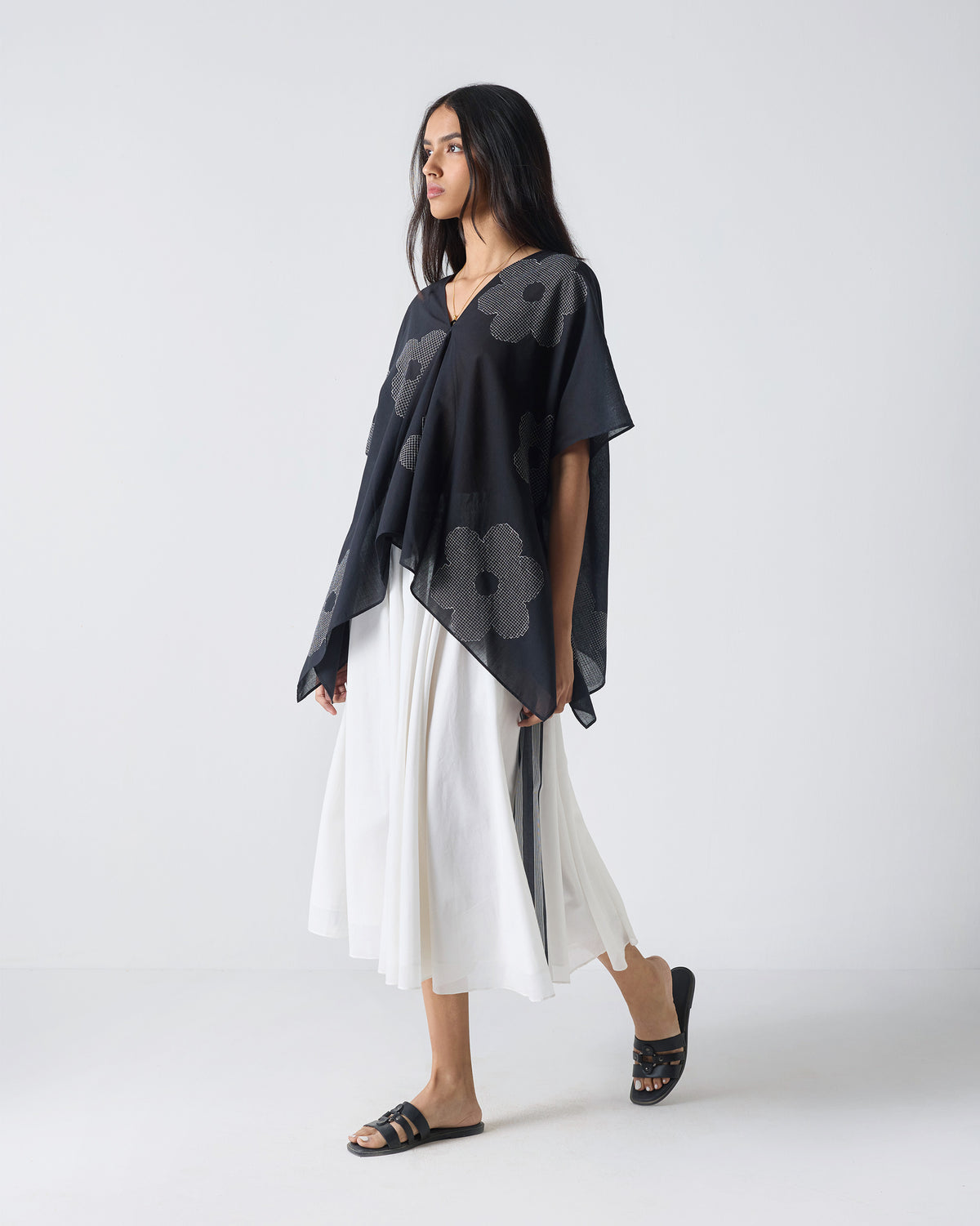 Black Curved Hem Top with flower embroidery showing a draped side hem.