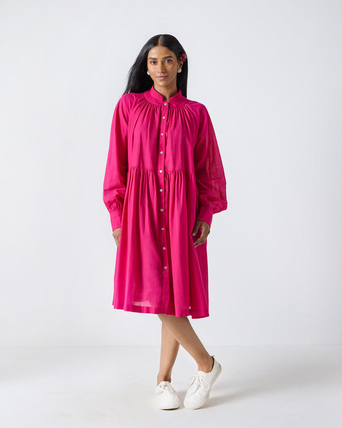 Person wearing a fuchsia Miya button-front dress with puff sleeves.