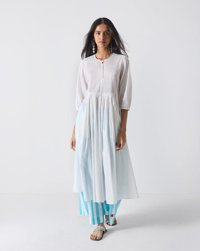 Person wearing a white Pleated Waist kurta with an empire waist and flared hem.