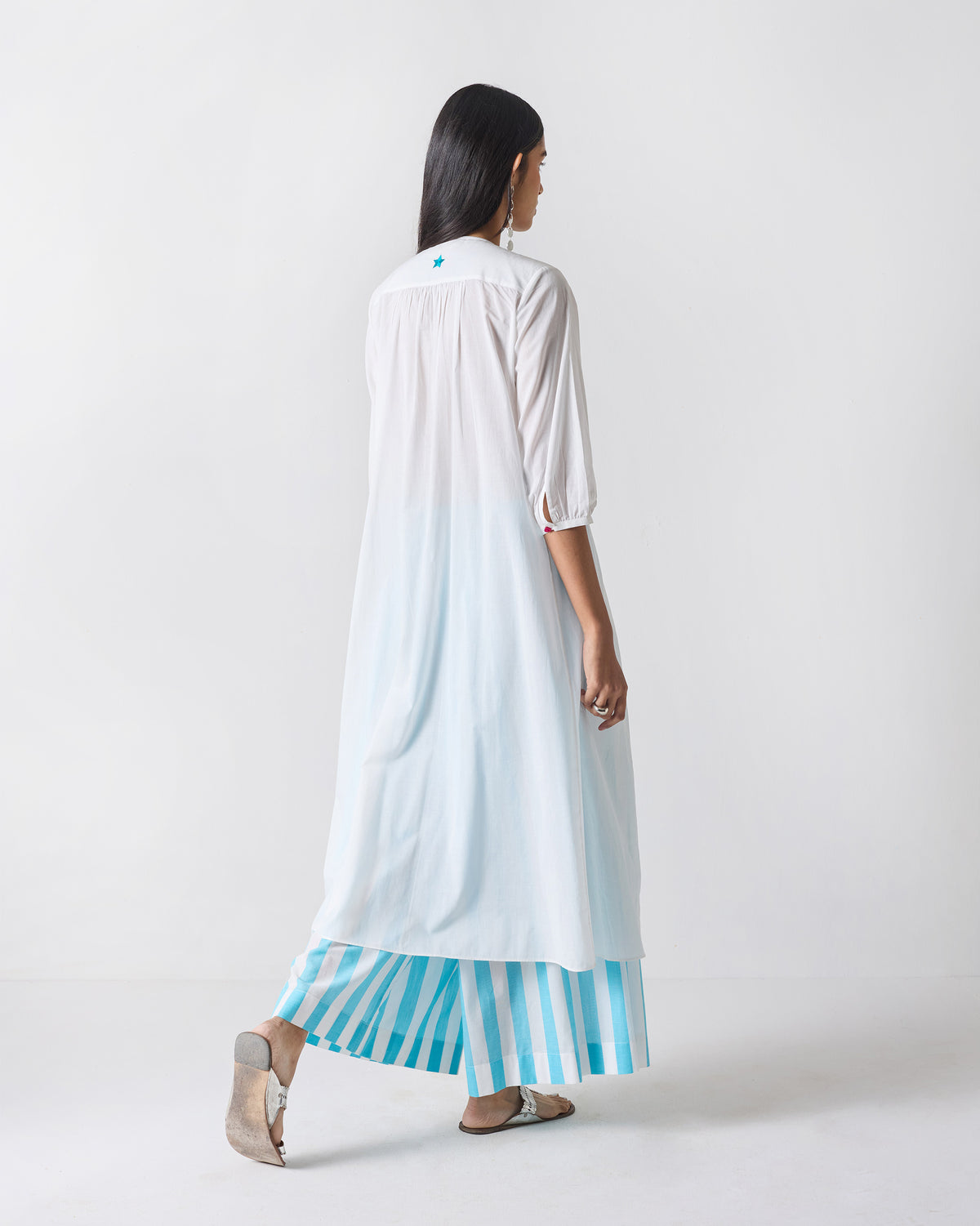 Back of a white Pleated Waist kurta showing the flared length and neck star.