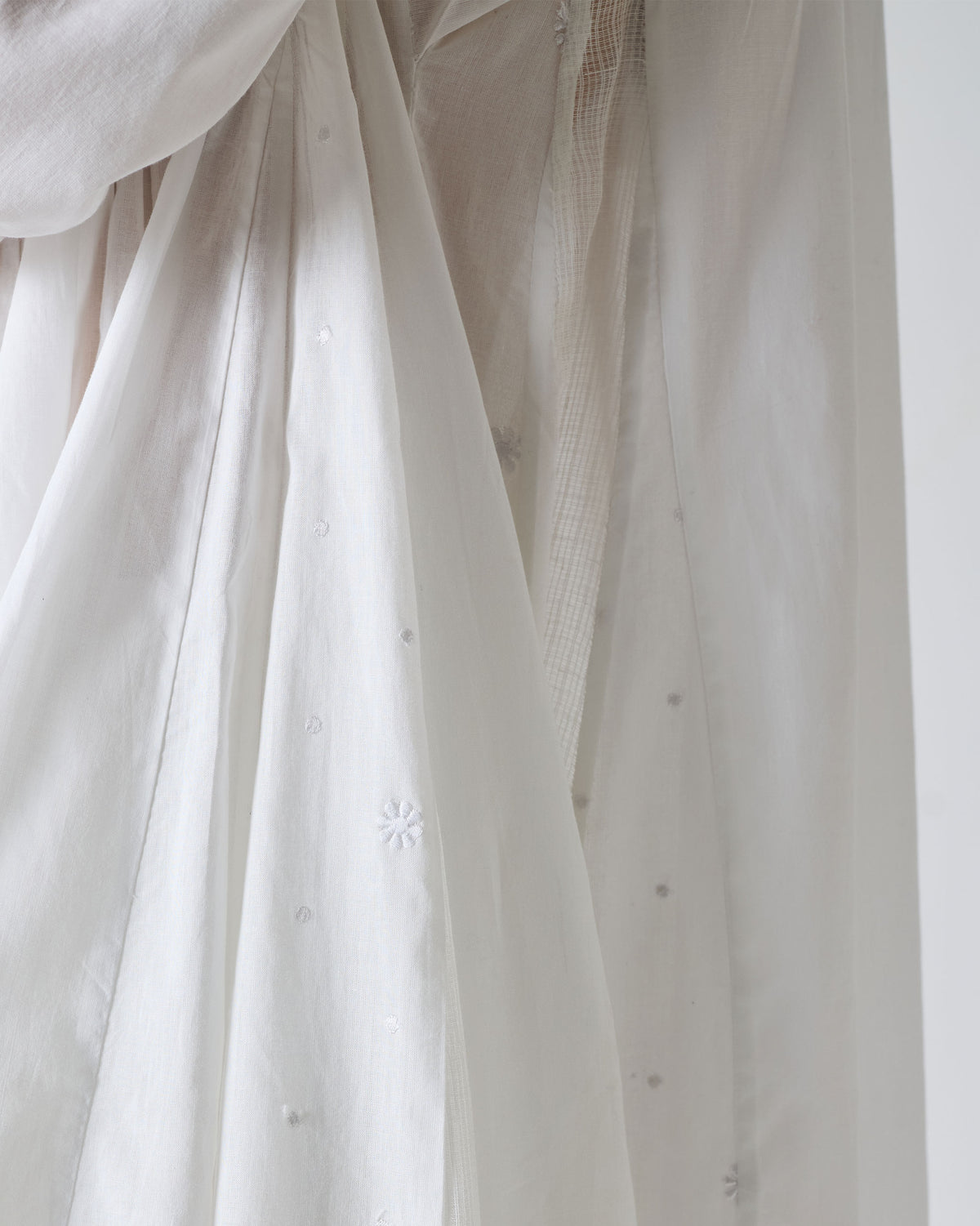 Close-up of a white kurta with tonal floral embroidery.