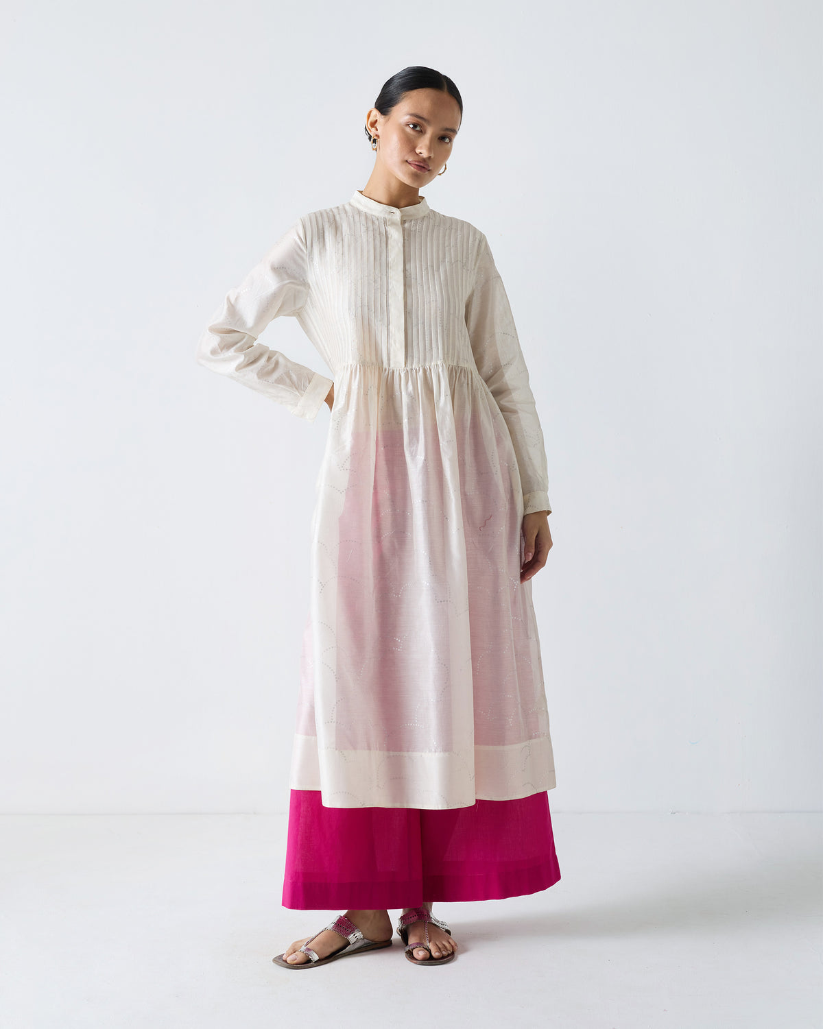 Person wearing fuchsia Basic Pyjamas under a sheer off-white tunic.
