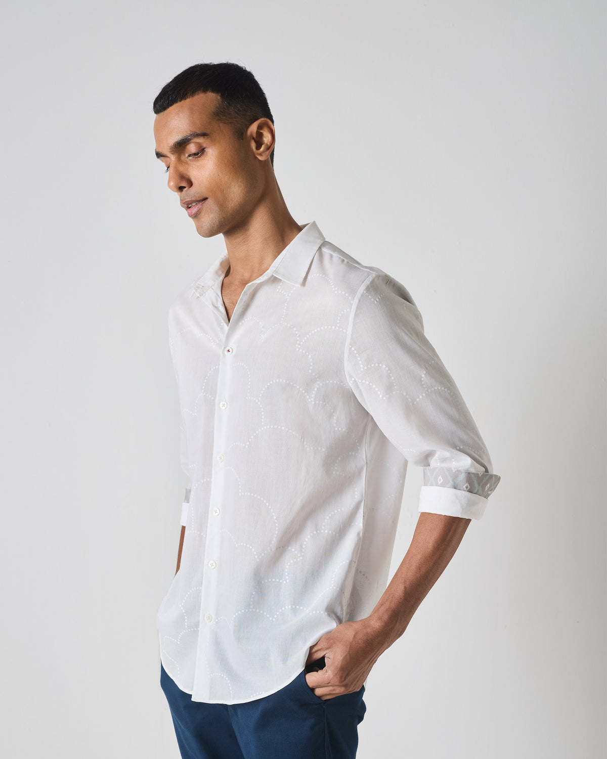 Side view of a white Hakuna Shirt with tonal wave embroidery and patterned cuff lining.