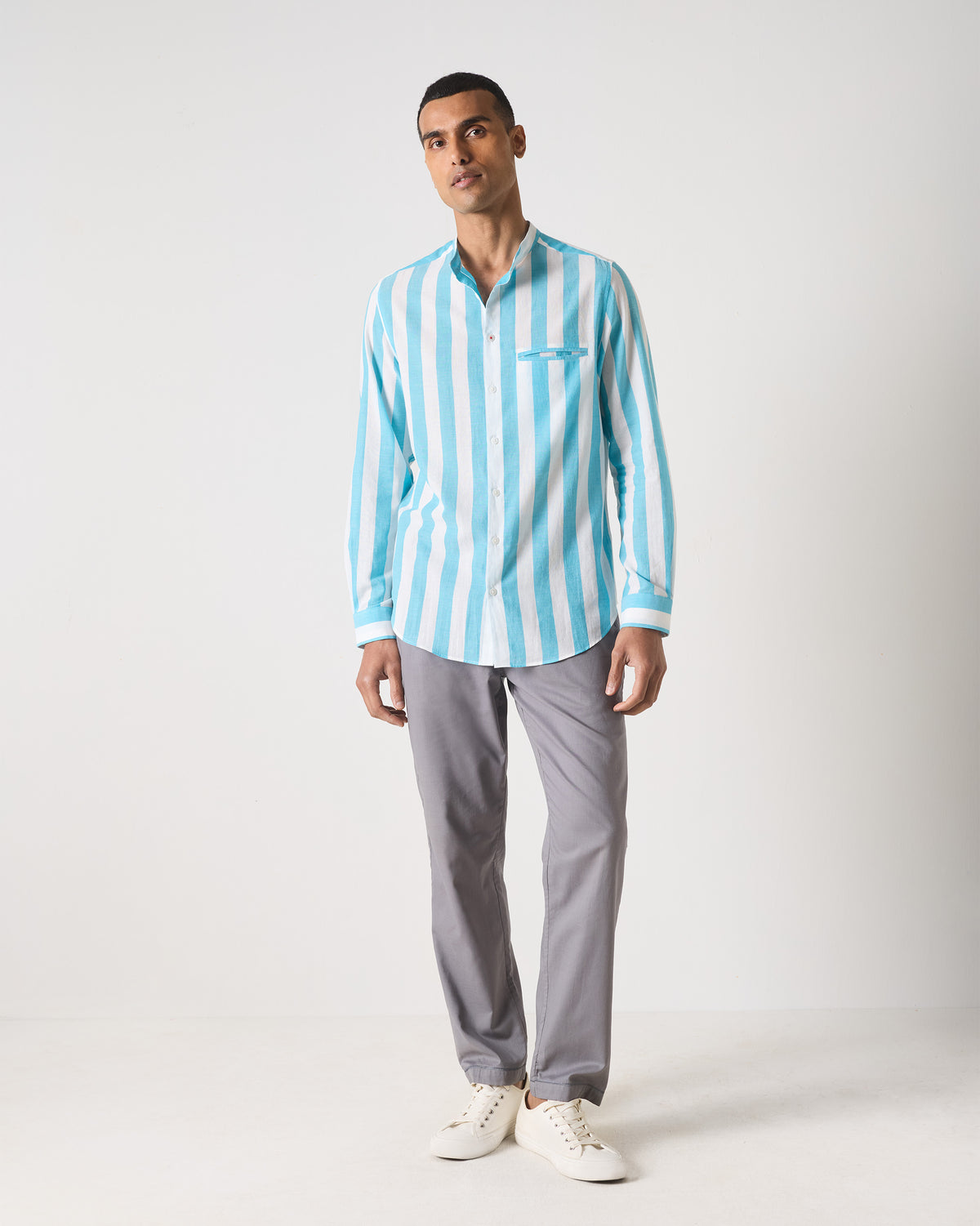 Person wearing a blue and white striped Slim Fit Shirt untucked.