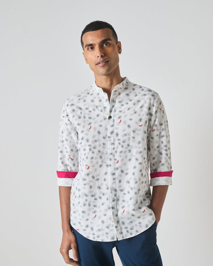 Person wearing a white One Button Shirt with a grey floral print and pink cuff lining.