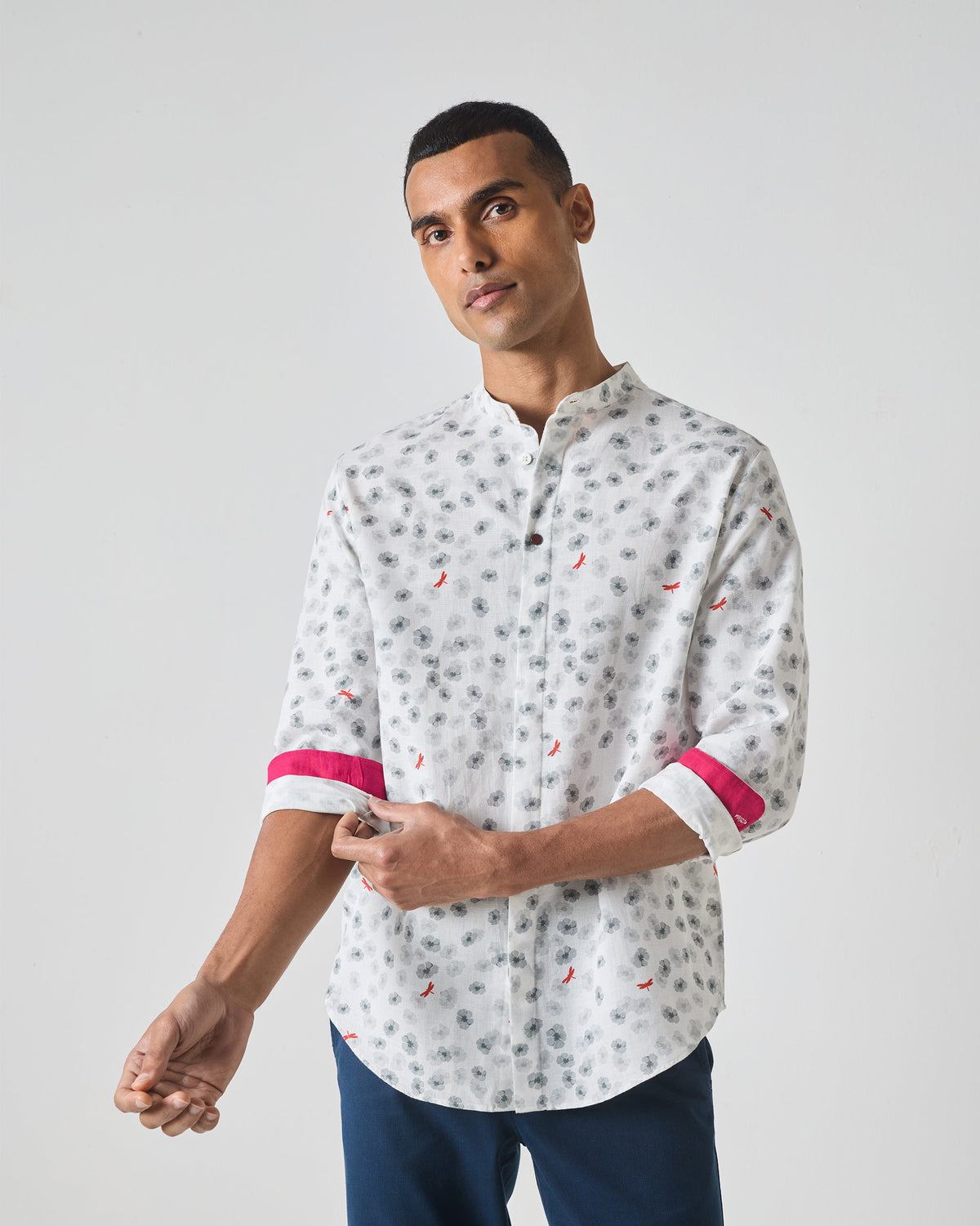Person wearing a white One Button Shirt showing pink cuff lining on rolled sleeves.