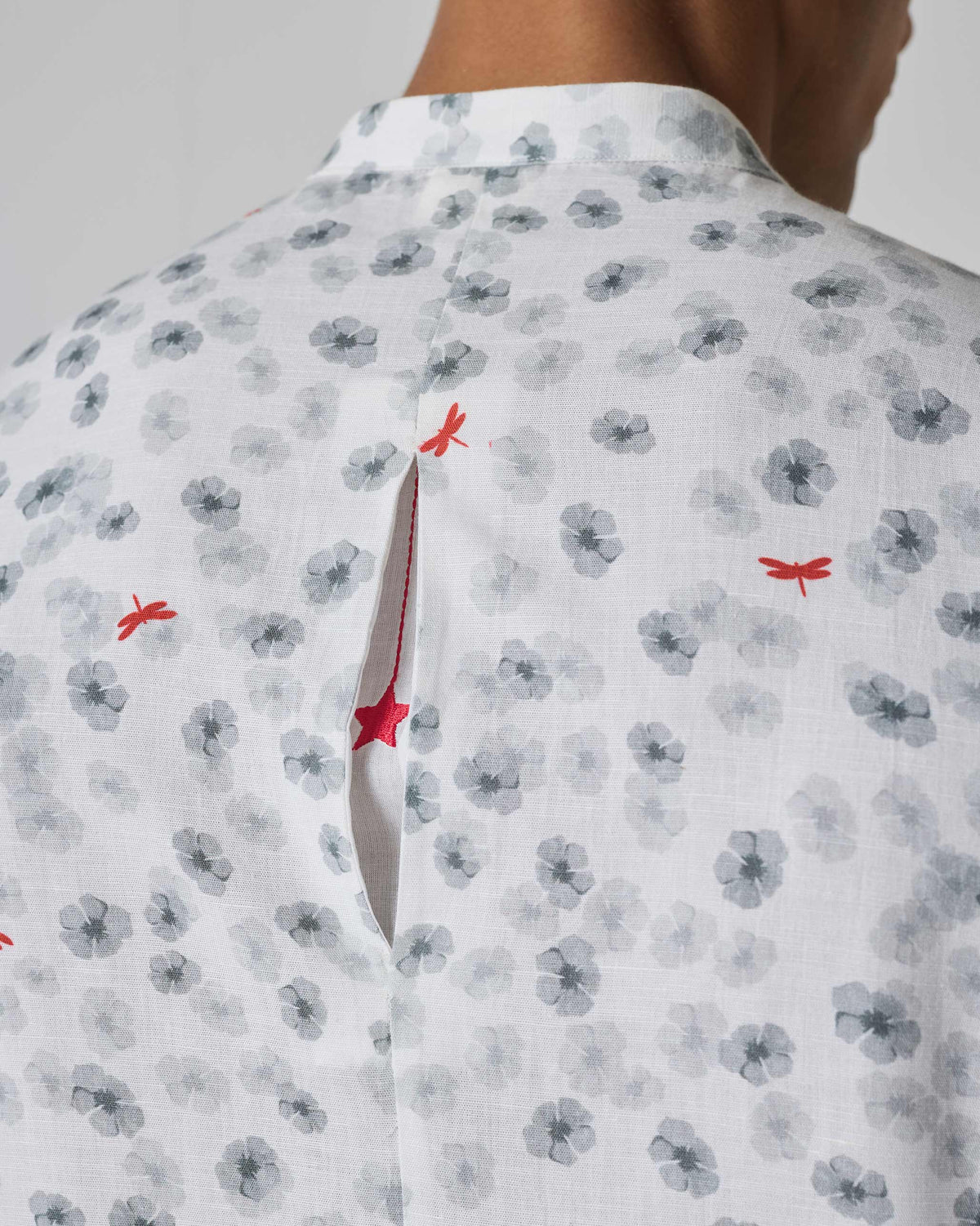 Close-up of a white One Button Shirt back pleat revealing a red star.