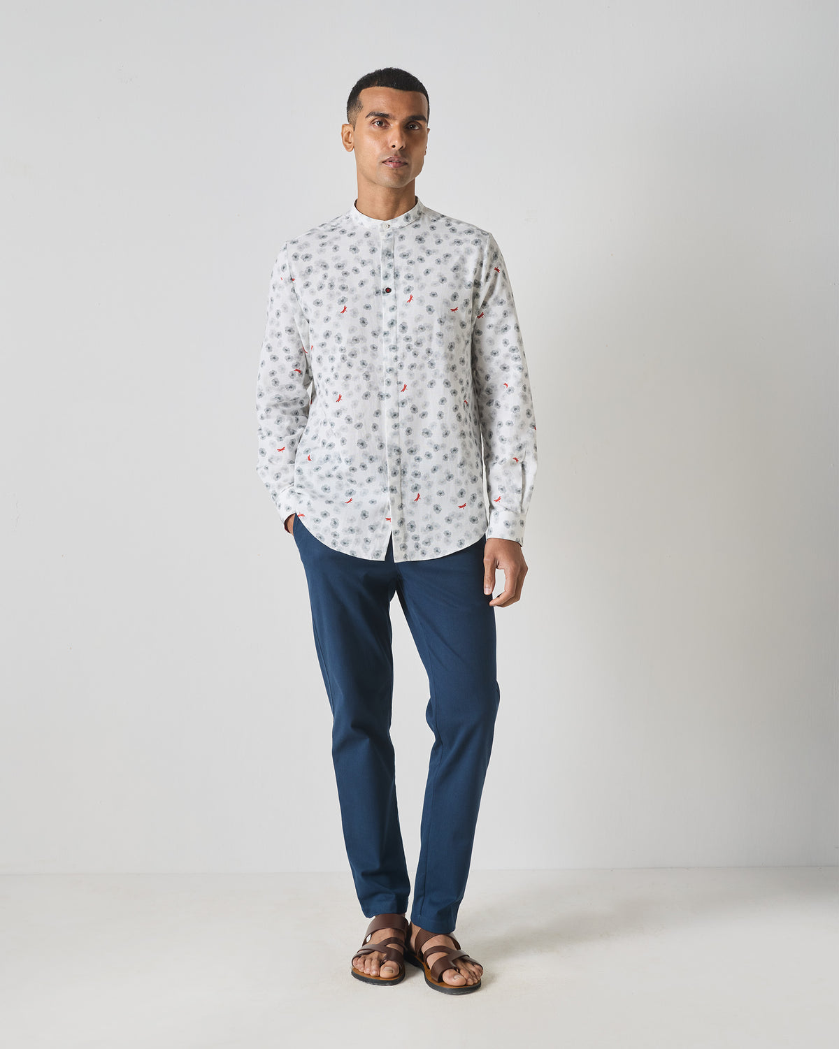 Person wearing a white One Button Shirt with a grey floral print and curved hem.