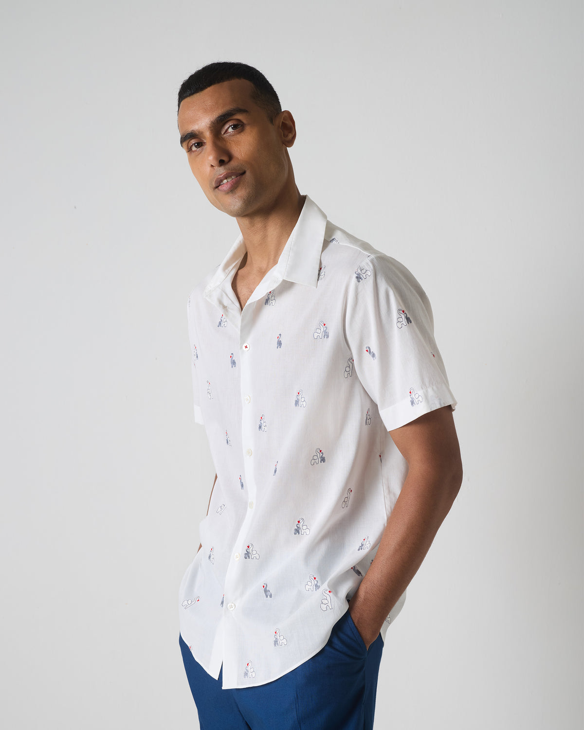 Side view of a white half sleeves shirt with scattered grey and black embroidery.
