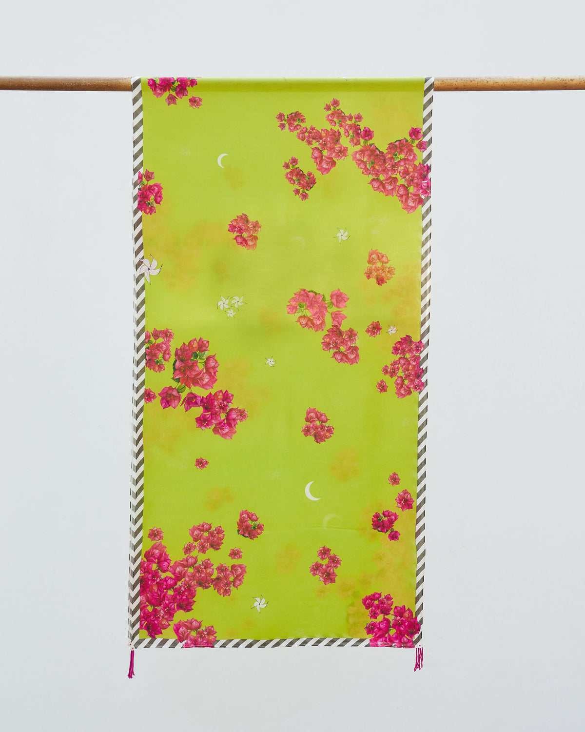 Full Bougainvillea scarf hung from a rod, lime green with pink blooms and a striped border.