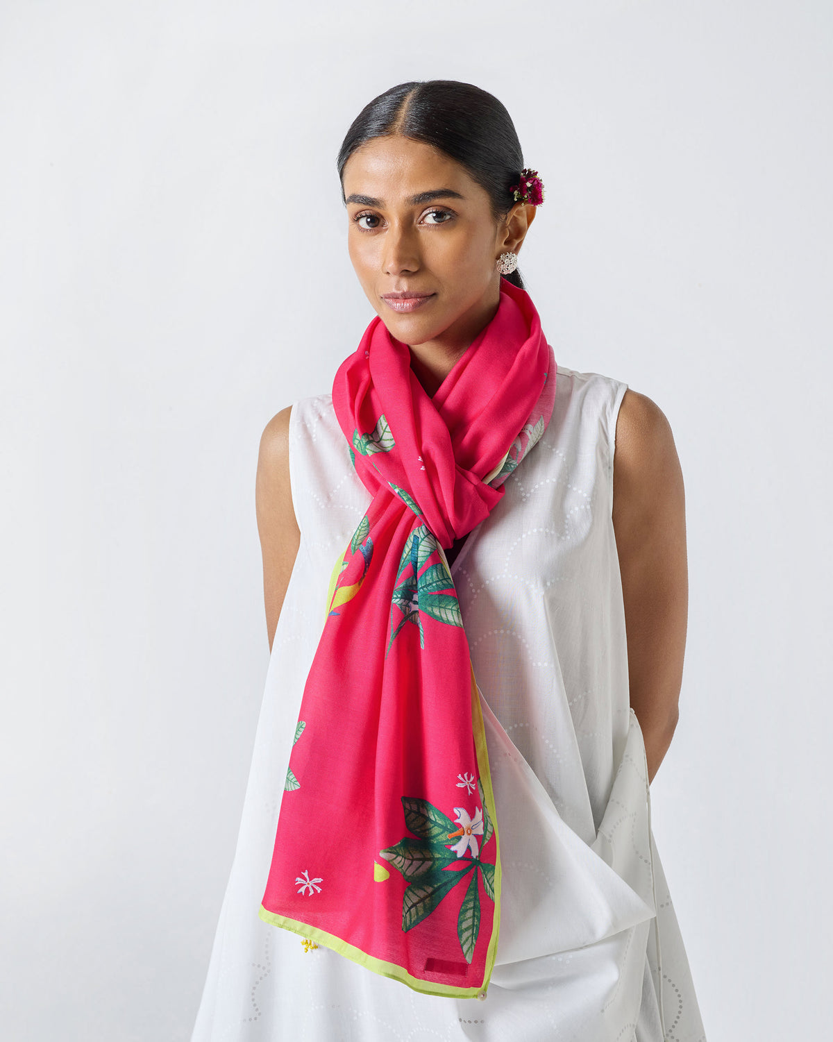 Person wearing a fuchsia Leaping Fish scarf with a leaf and flower print.