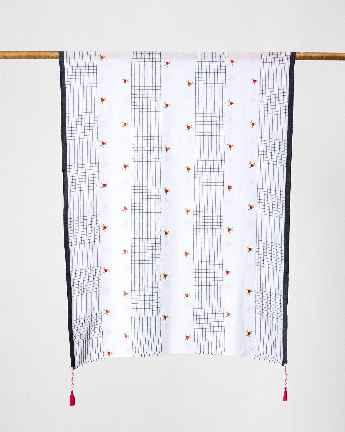 Rose Bloom scarf hung flat, showing black grid bands and pink rose motifs on white.