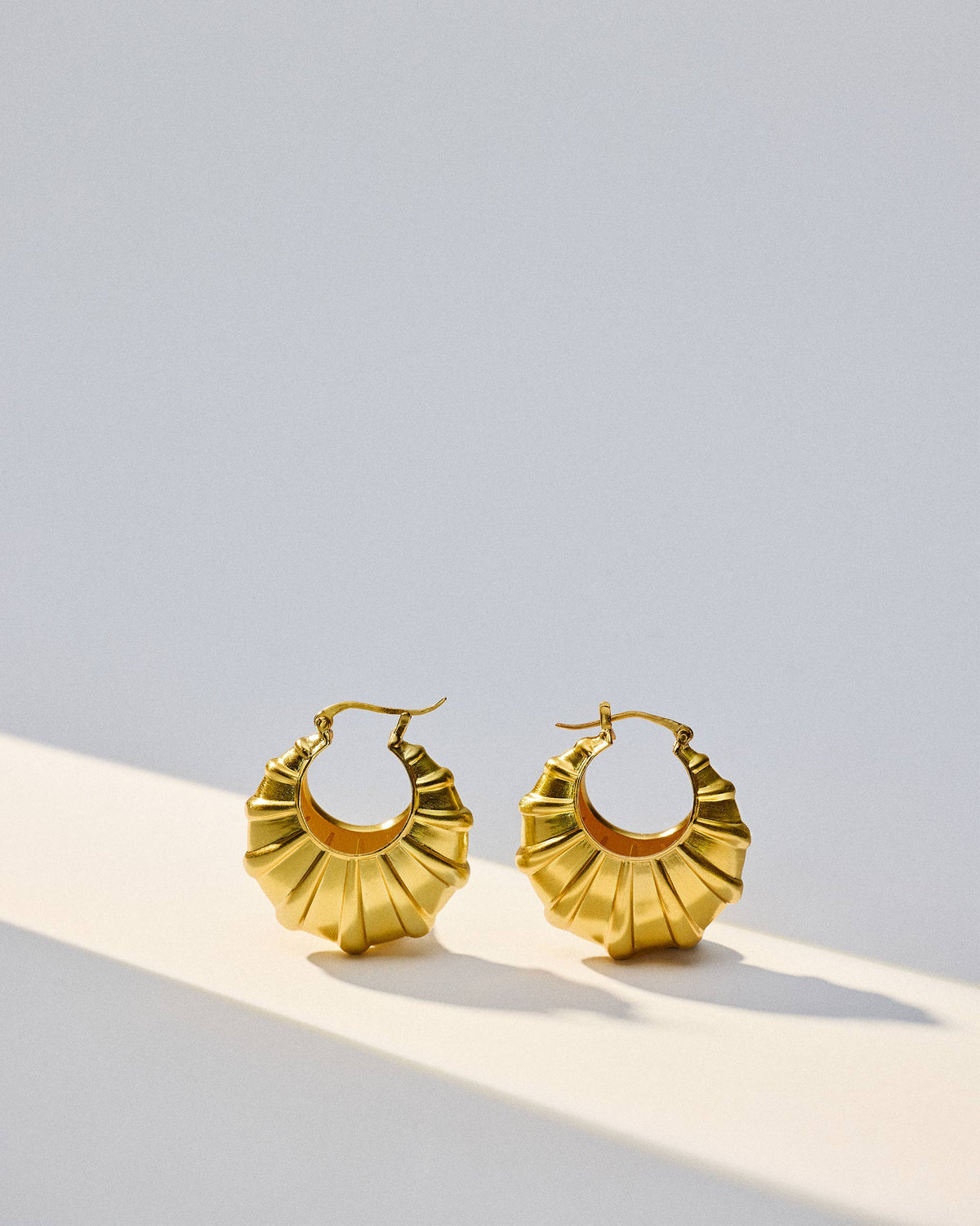 Pair of gold Shell Balis with fluted, shell-shaped hoops.