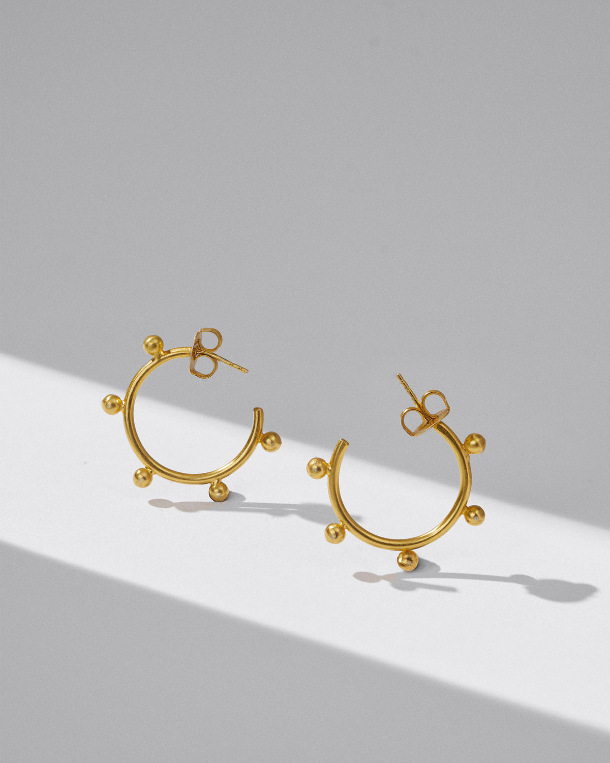 Pair of gold Sunshine open hoops with bead accents.
