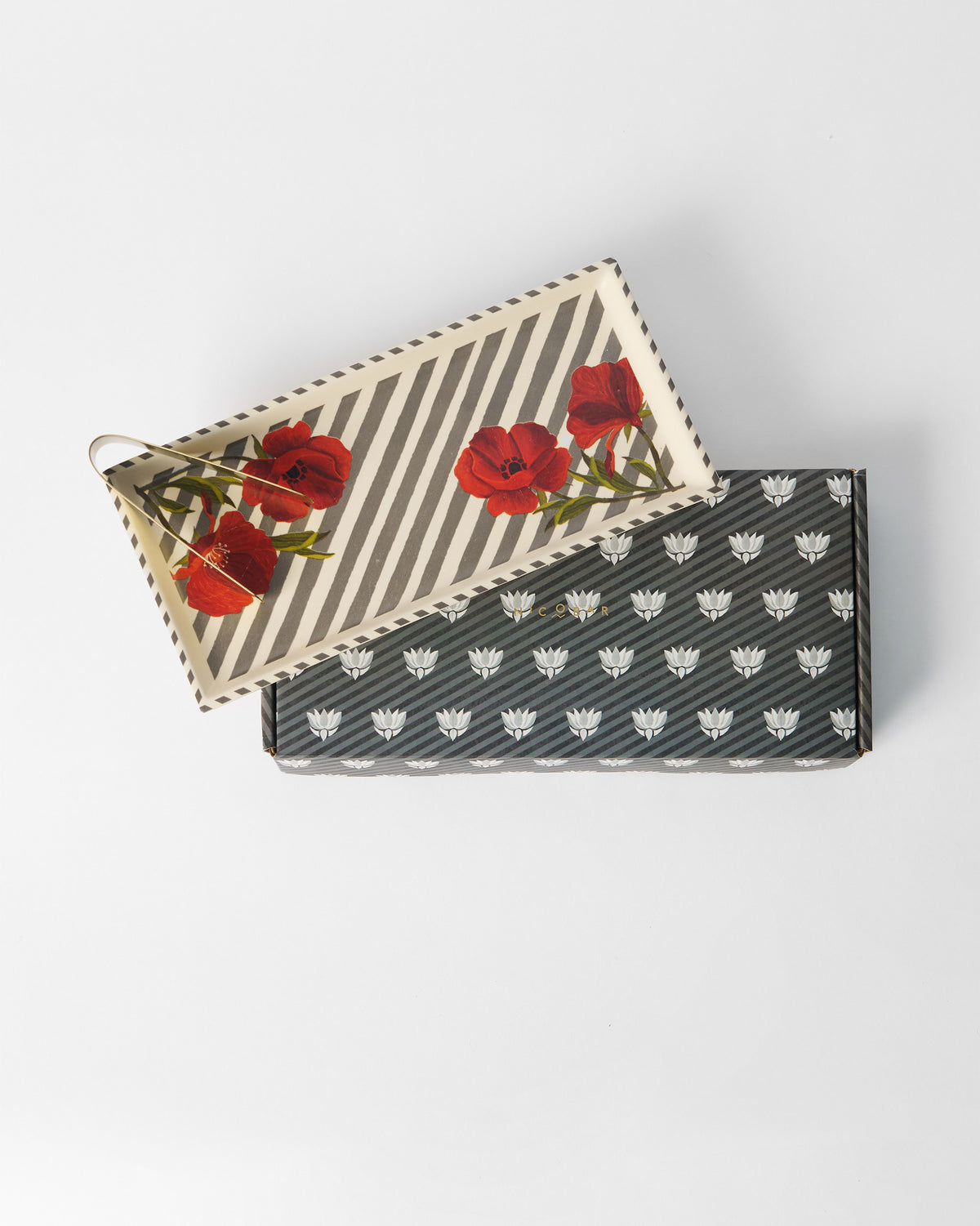 Striped Poppy cookie tray with tongs displayed on a Nicobar gift box.