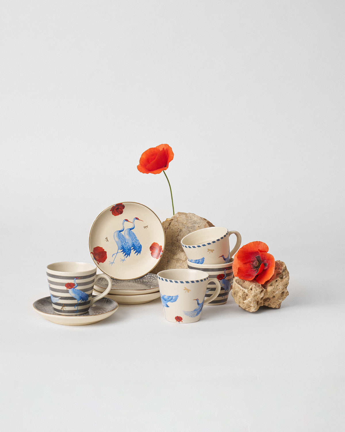 Dancing Crane mugs and plates mixing crane, poppy, stripe, and gold dragonfly motifs.