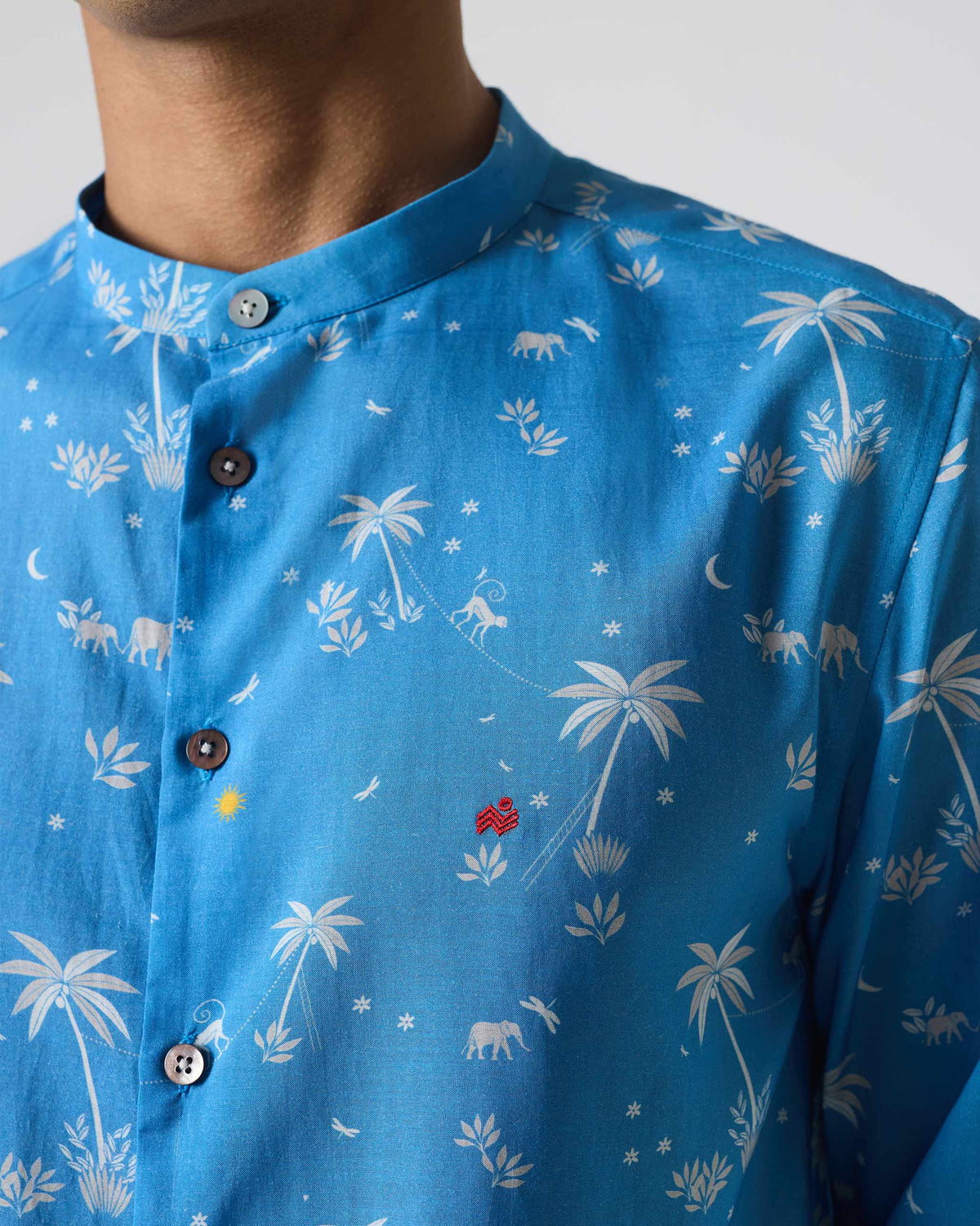 Close-up of white palm and animal print on a blue Nawab shirt.