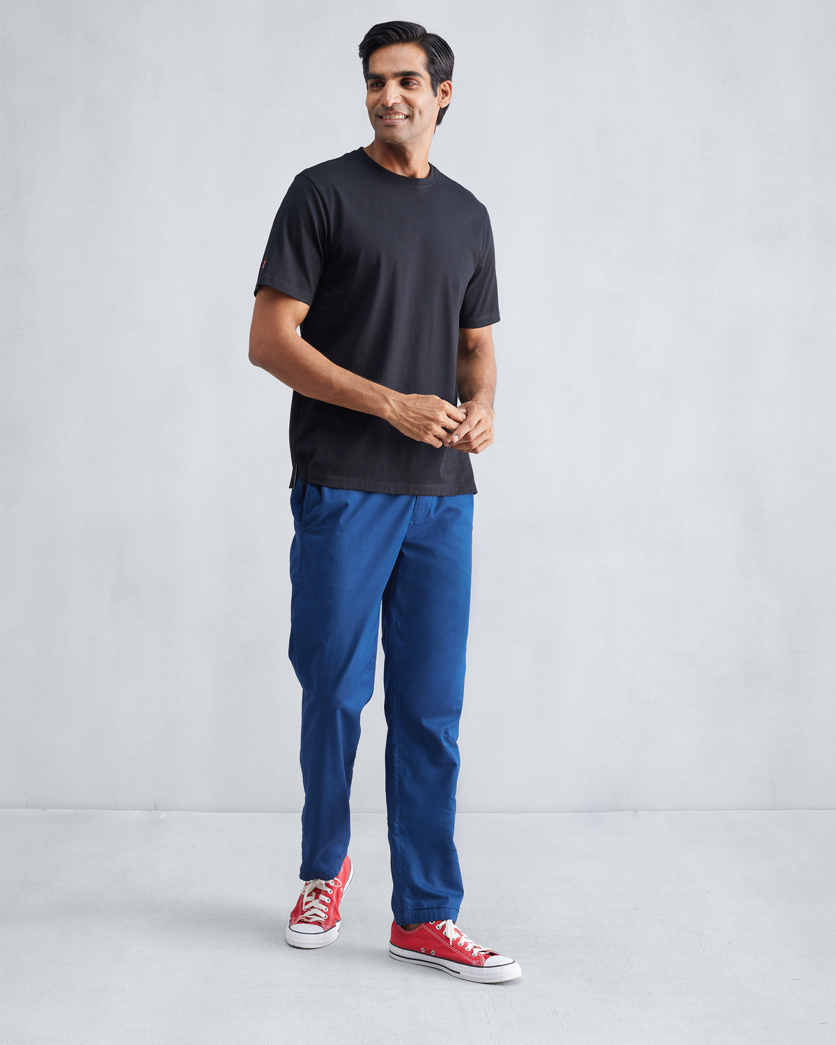 Person wearing a black Everyday T-shirt with a crew neck and short sleeves.