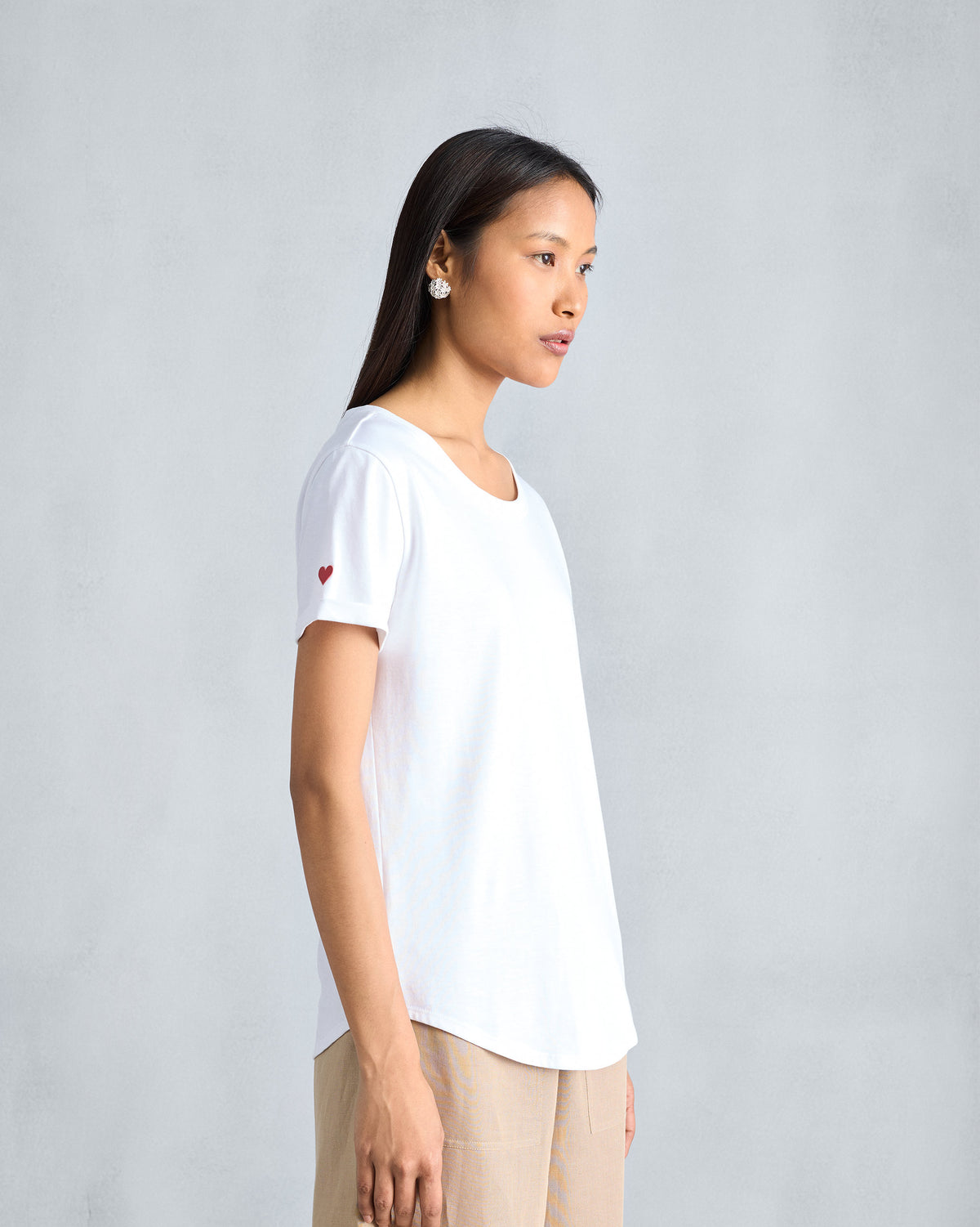 Side view of a white Basic T-Shirt with a red heart on the sleeve.