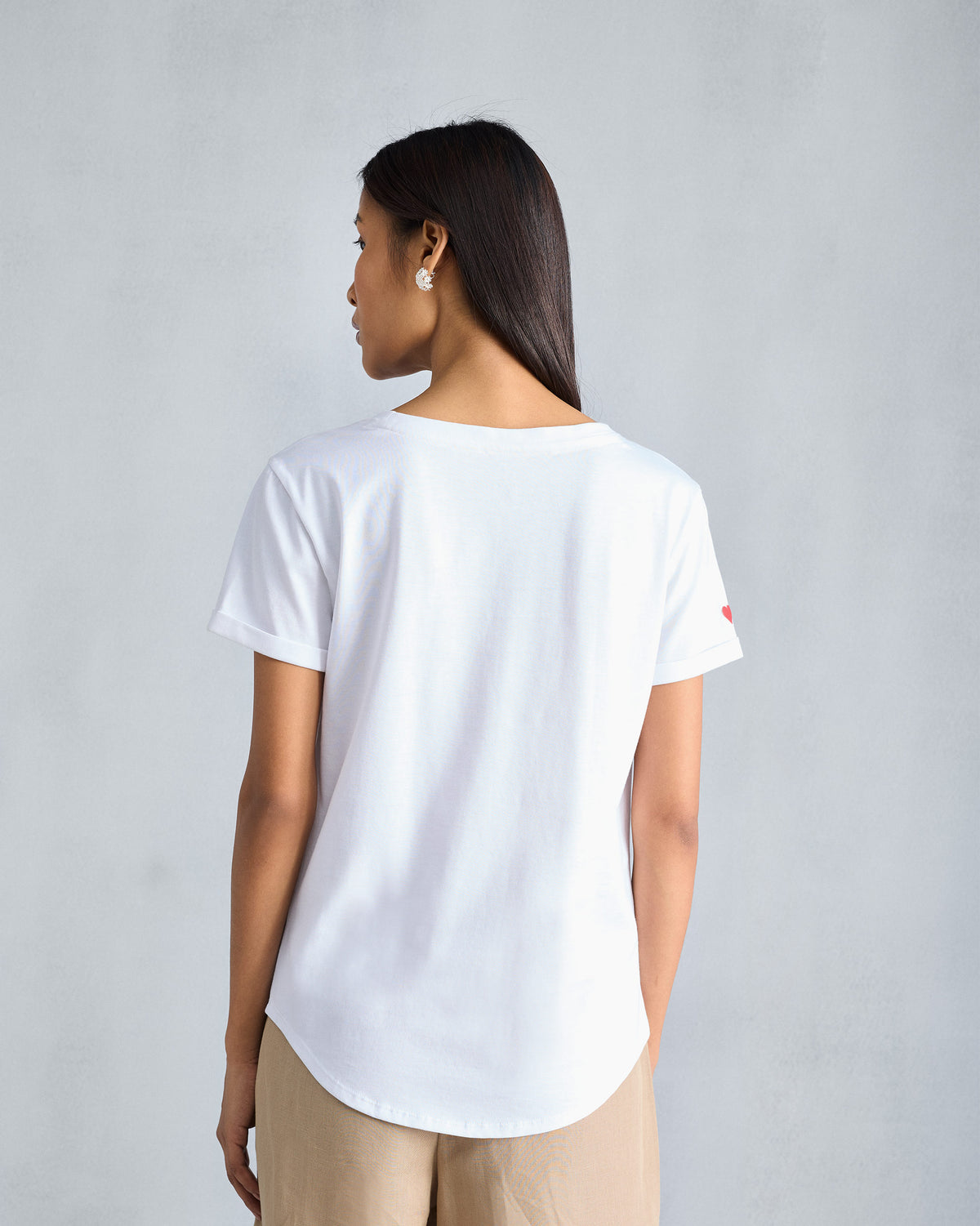Back of a white Basic T-Shirt with a red heart on the sleeve.