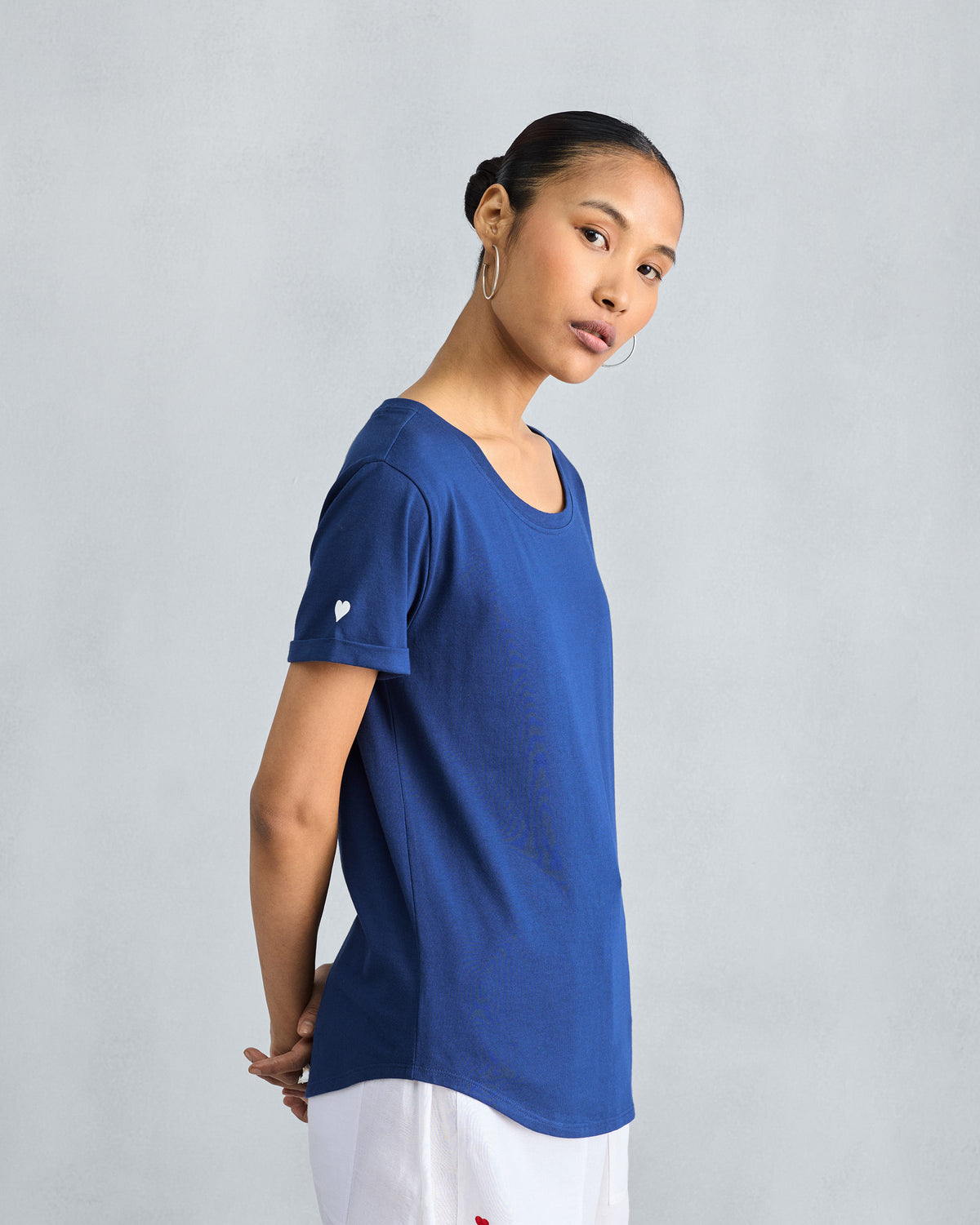 Side view of a navy Basic T-Shirt with a curved shirttail hem.