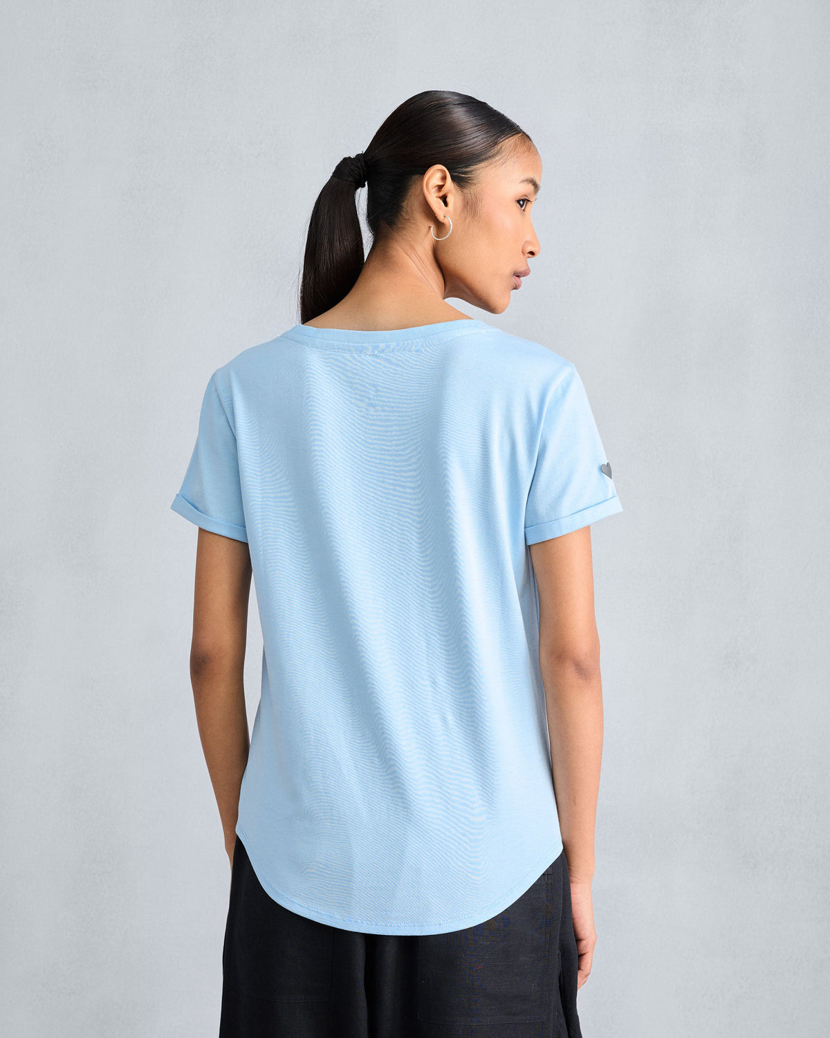 Back of a light blue Basic t-shirt with a curved hem.