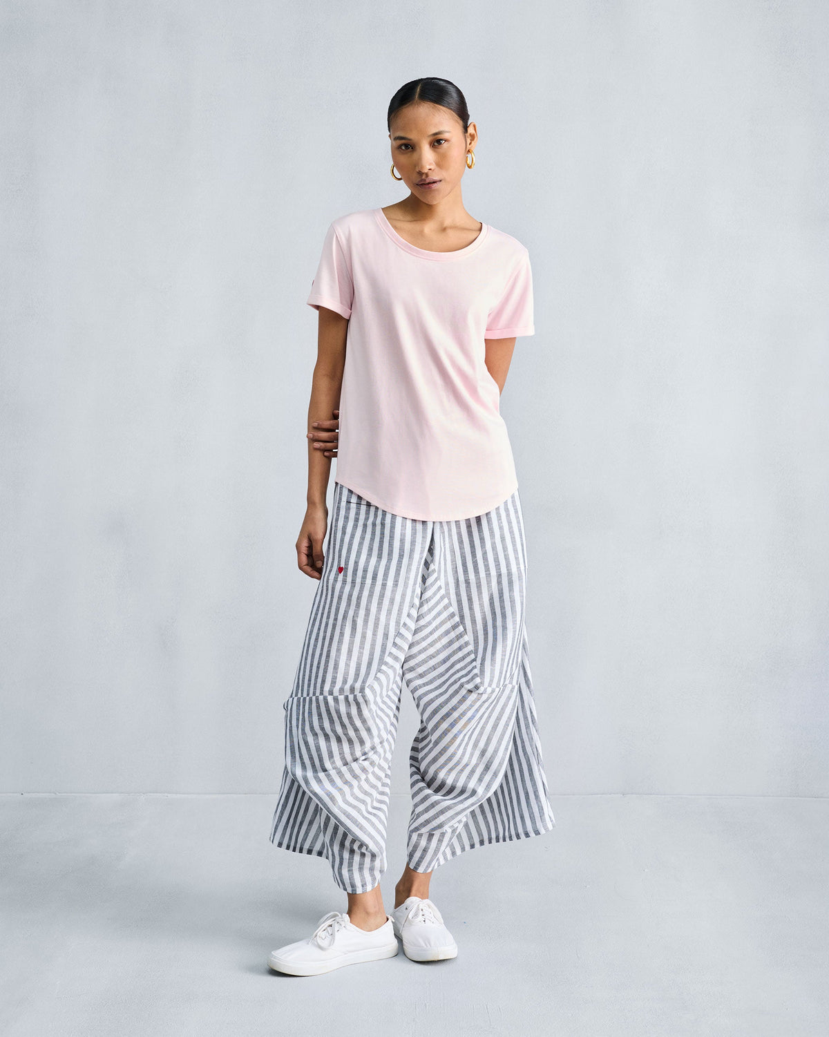 Person wearing the Basic T-Shirt in blush pink, shown full length.