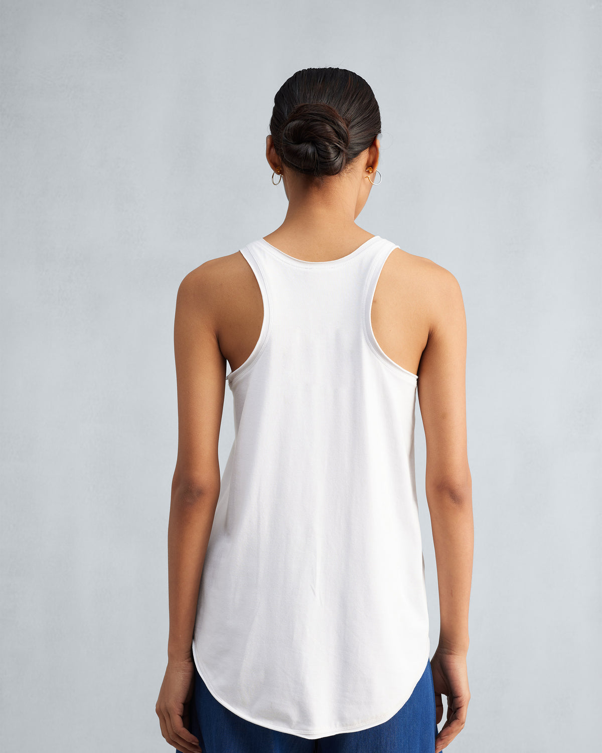 Back of a white Ukiyo racerback tank with a curved hem.
