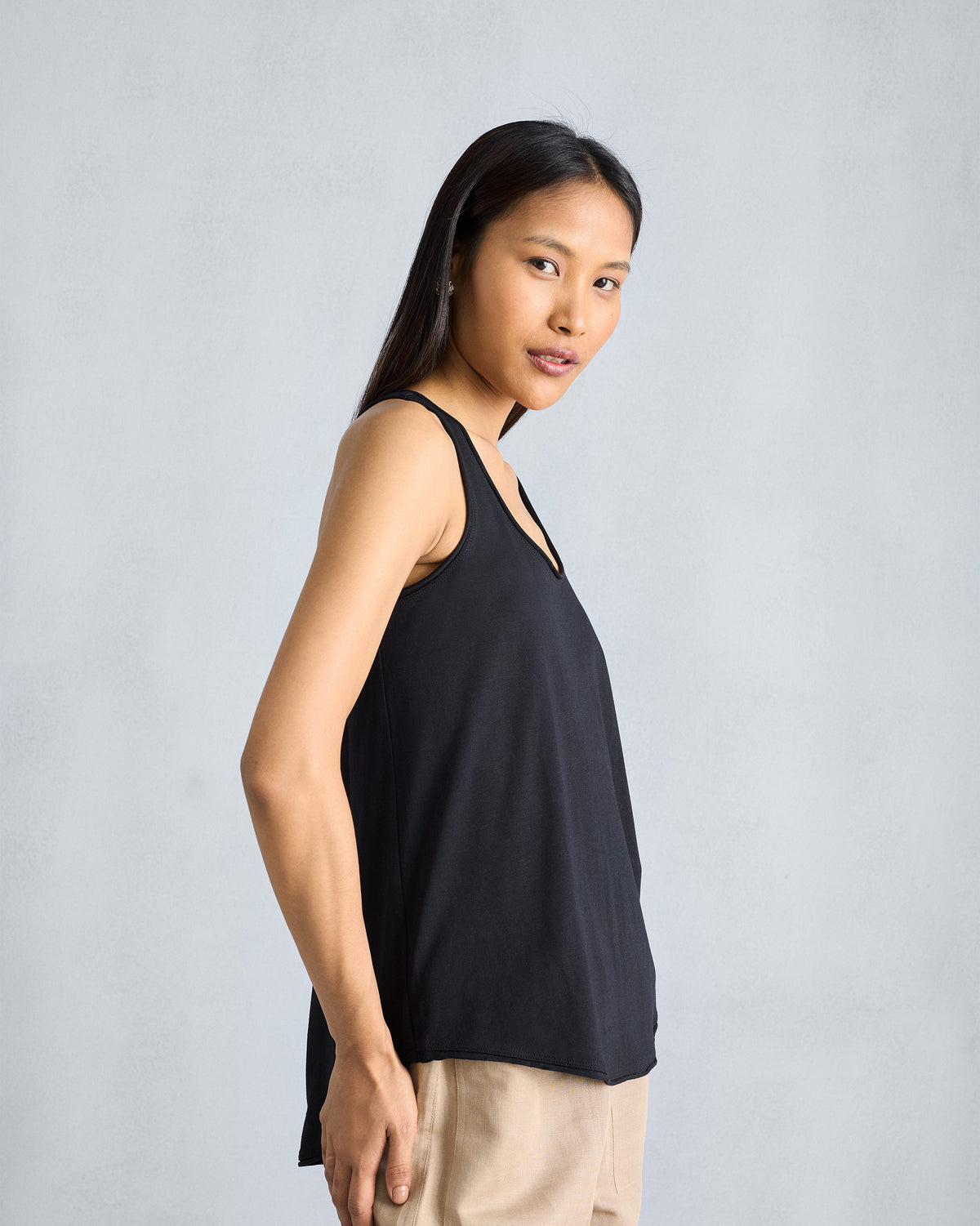 Side view of a black Ukiyo tank showing the wide armhole and drape.