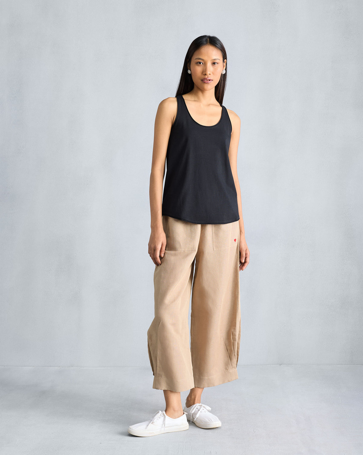 Person wearing a black Ukiyo racerback tank in a full-length view.