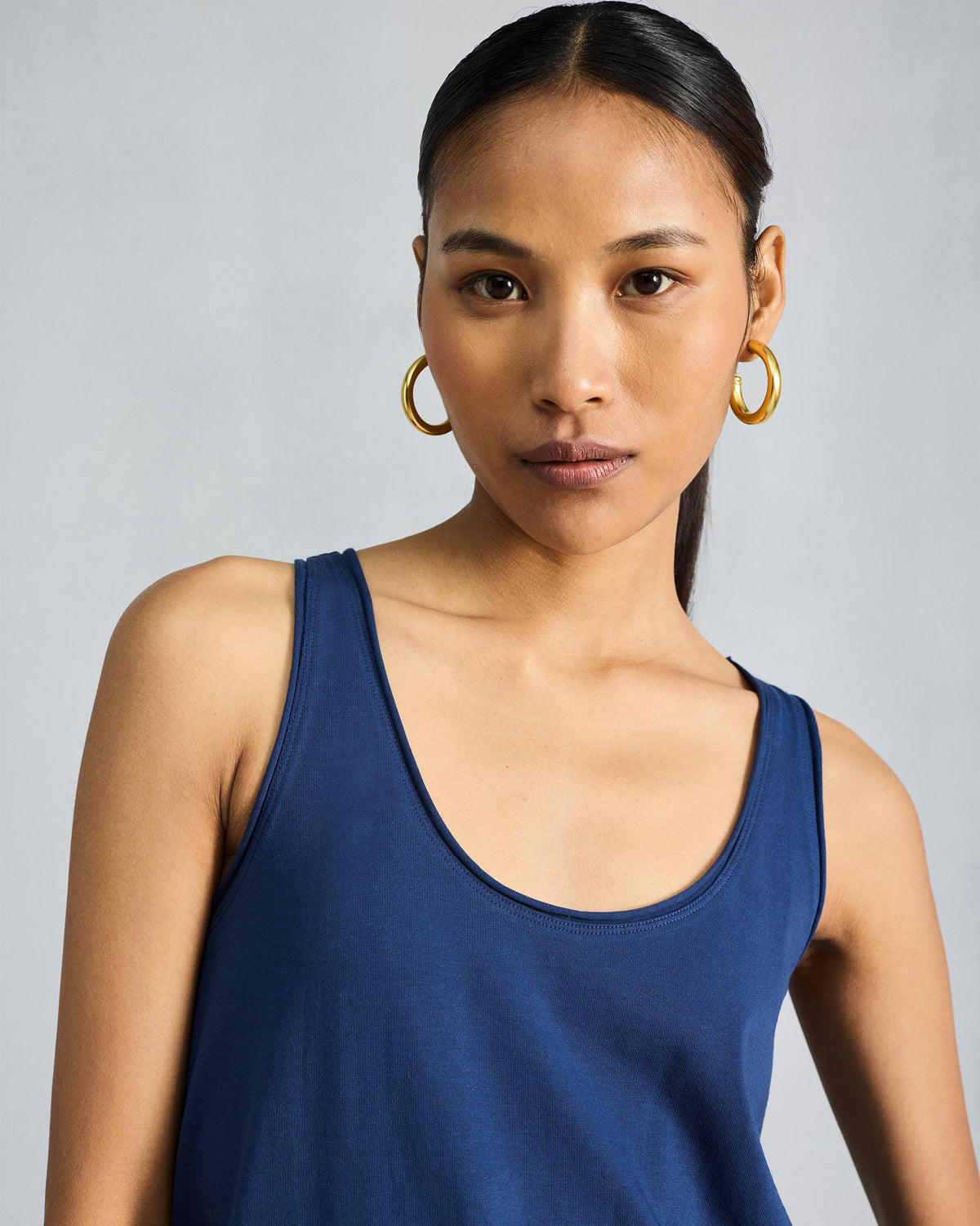 Close-up of a navy tank with a scoop neckline and wide straps.
