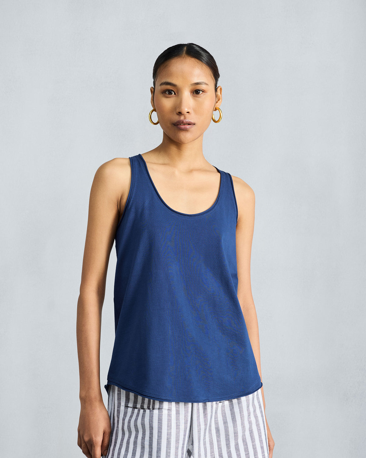 Person wearing a navy scoop-neck racerback tank.