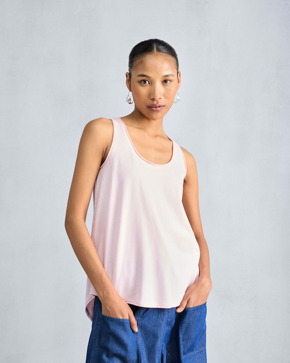 Person wearing a light pink Ukiyo tank with a relaxed scoop neck.