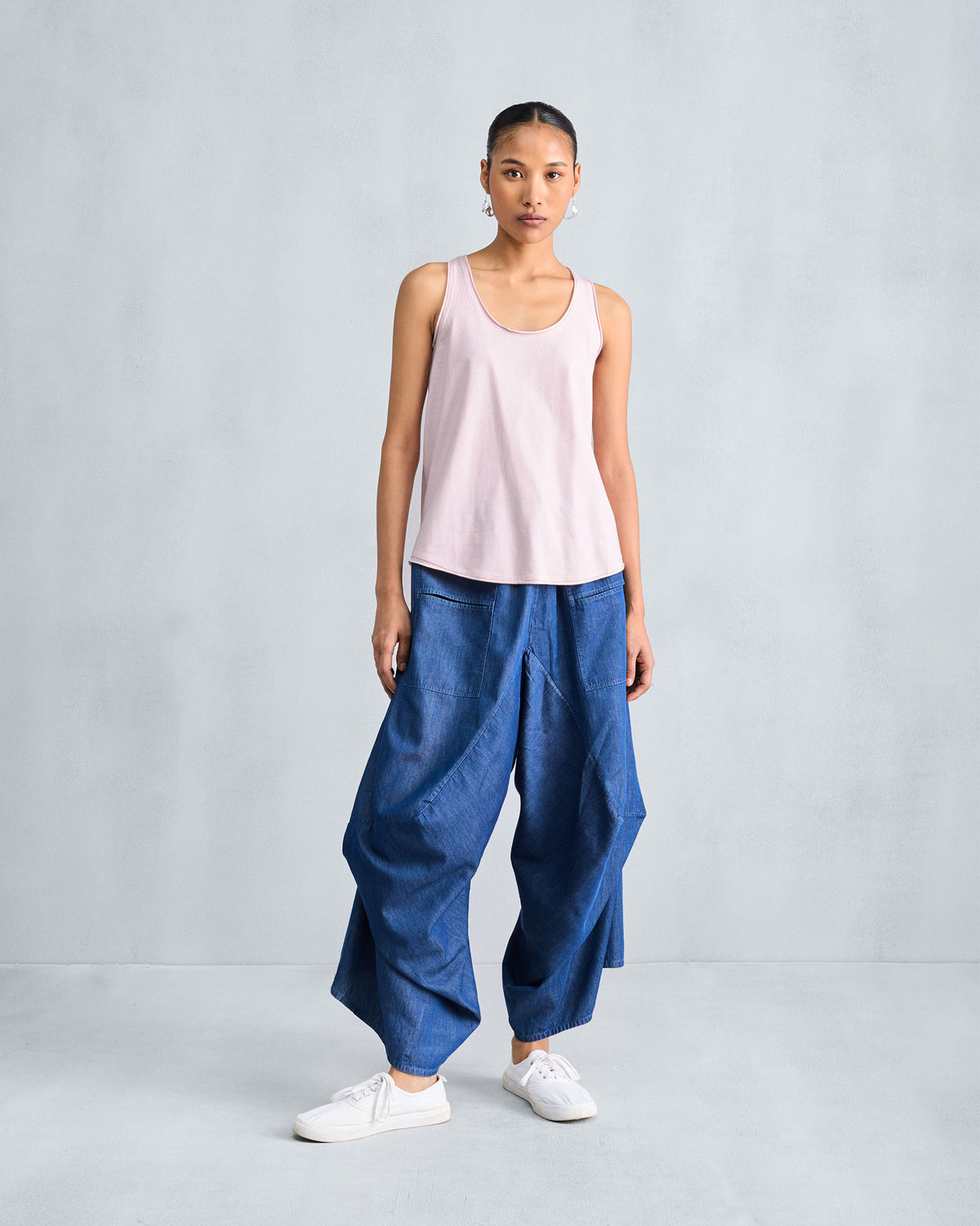 Person wearing a light pink Ukiyo racerback tank in a full-length view.