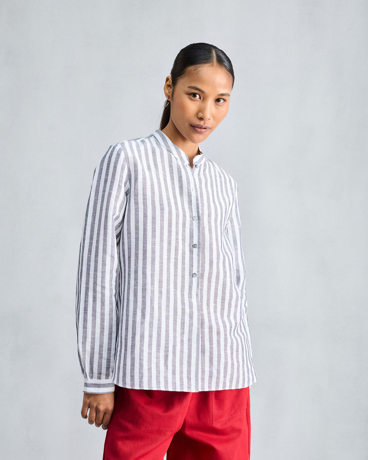 Person wearing a charcoal and white striped mandarin collar top.